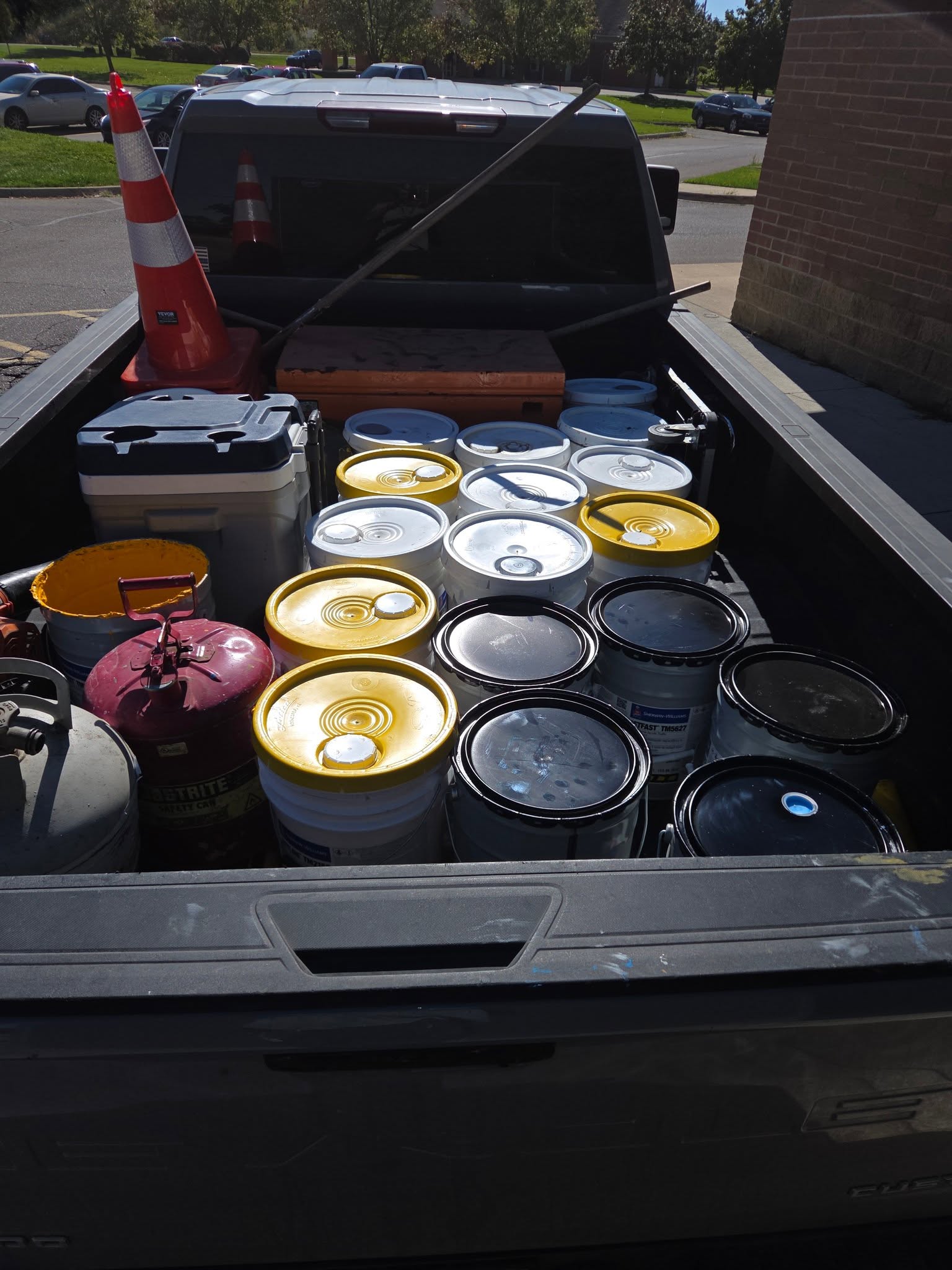 Truck bed loaded with paint, cones and equipment