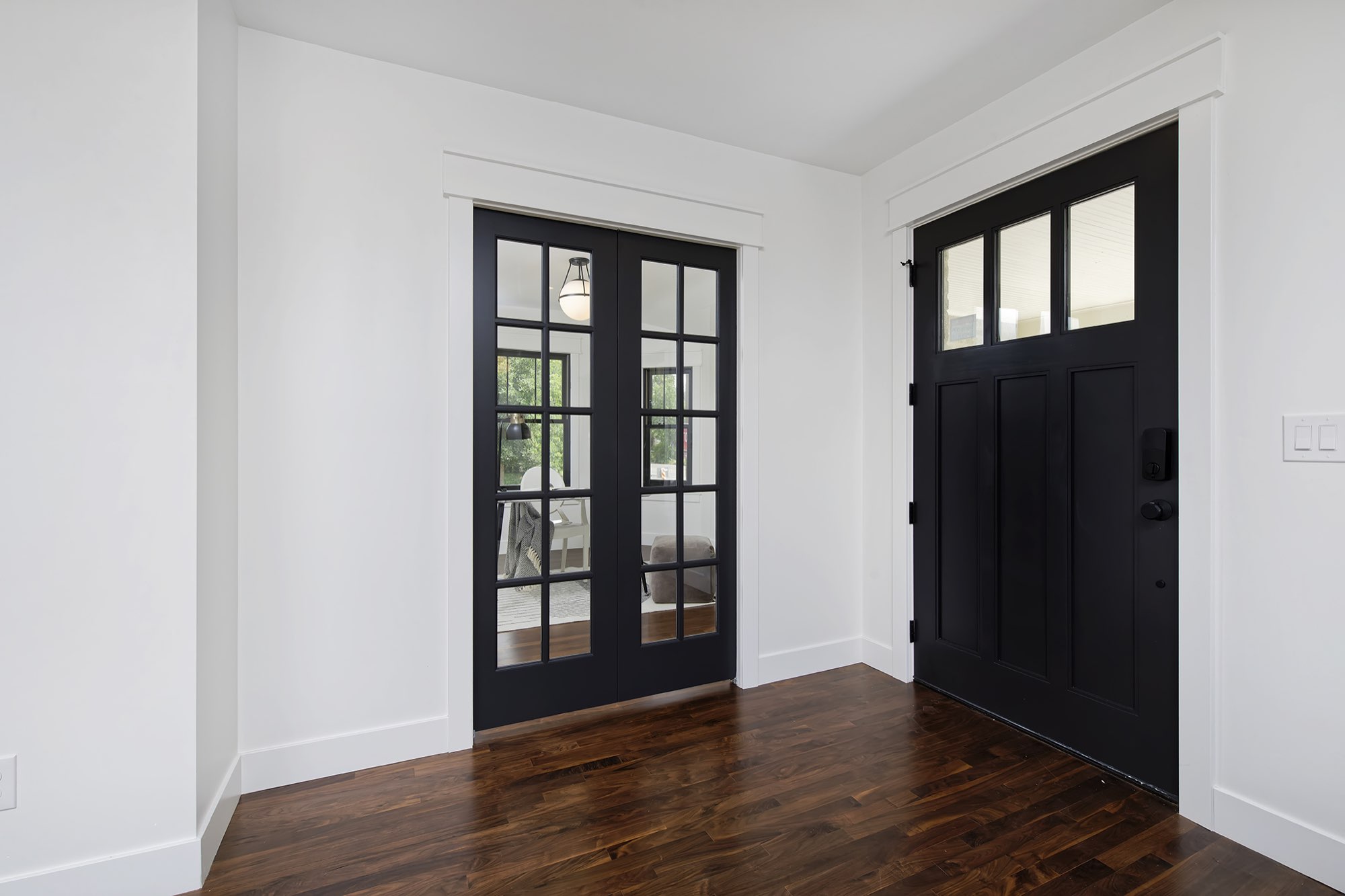 Entry with a black craftsman front door and black French doors with divided glass leading to the study