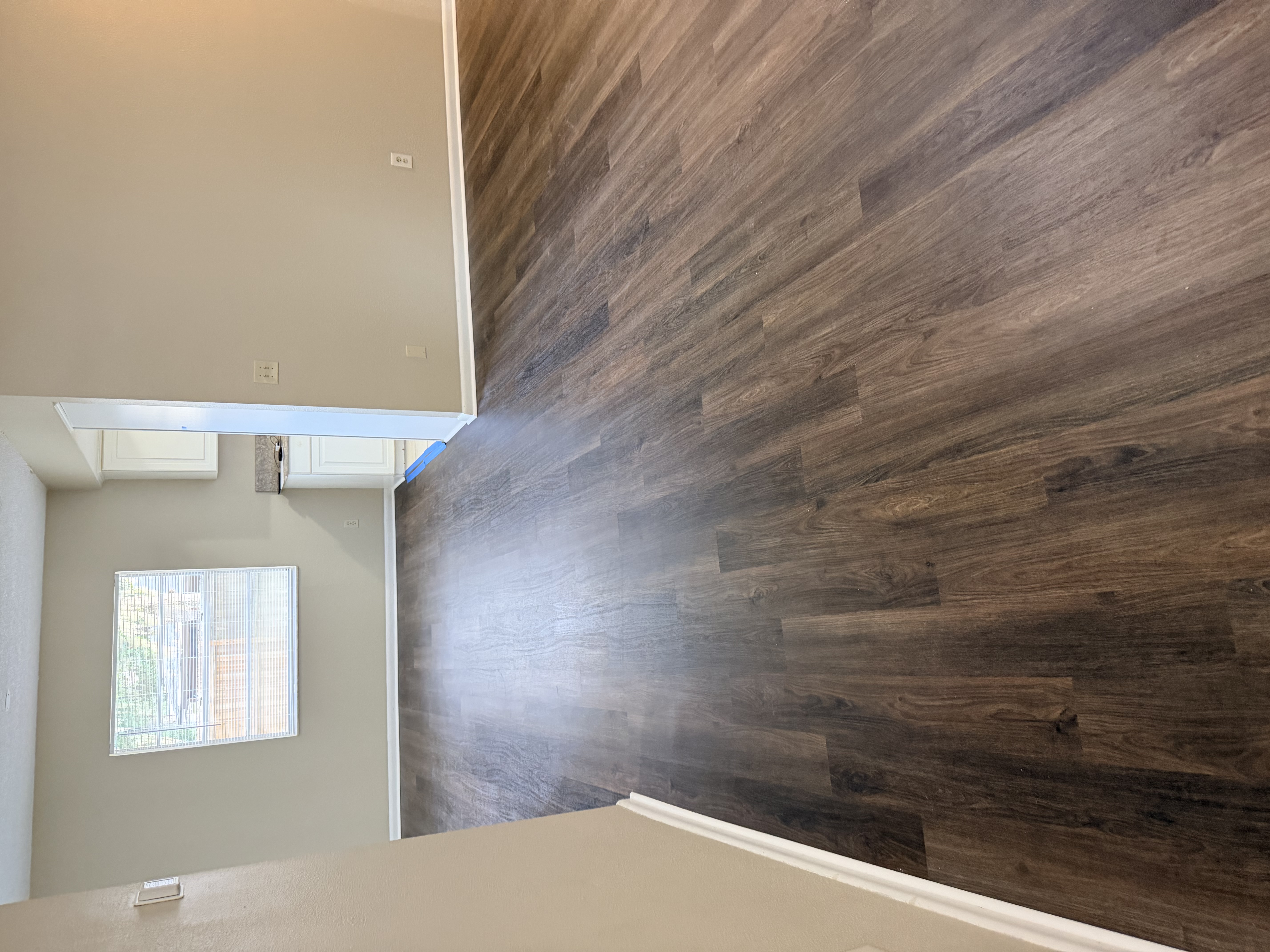 Open-plan Tampa, FL hallway with new dark plank flooring leading to the kitchen