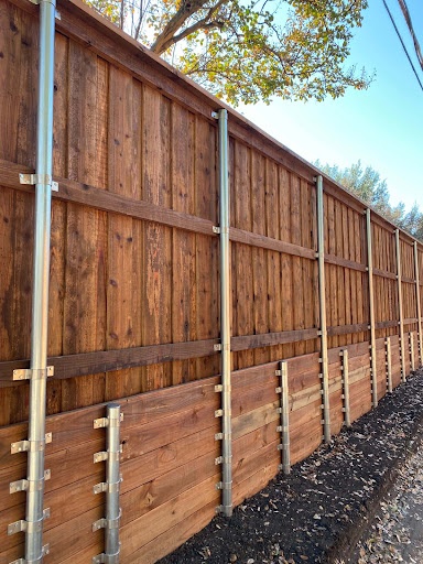 Close view of a stained cedar fence showing galvanized steel post and bracket construction in Texarkana, TX