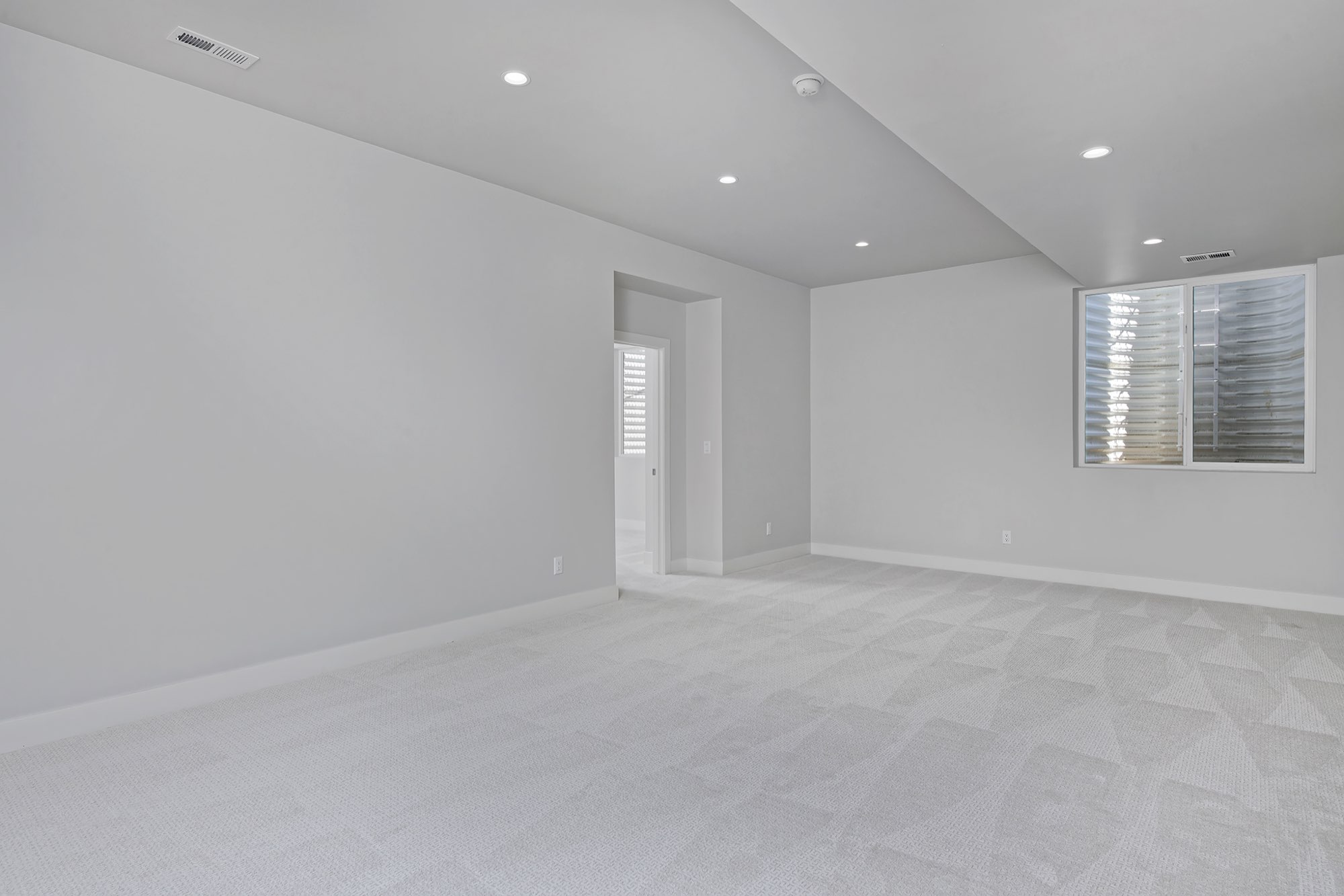 Lower level room with a window and a doorway toward the stair