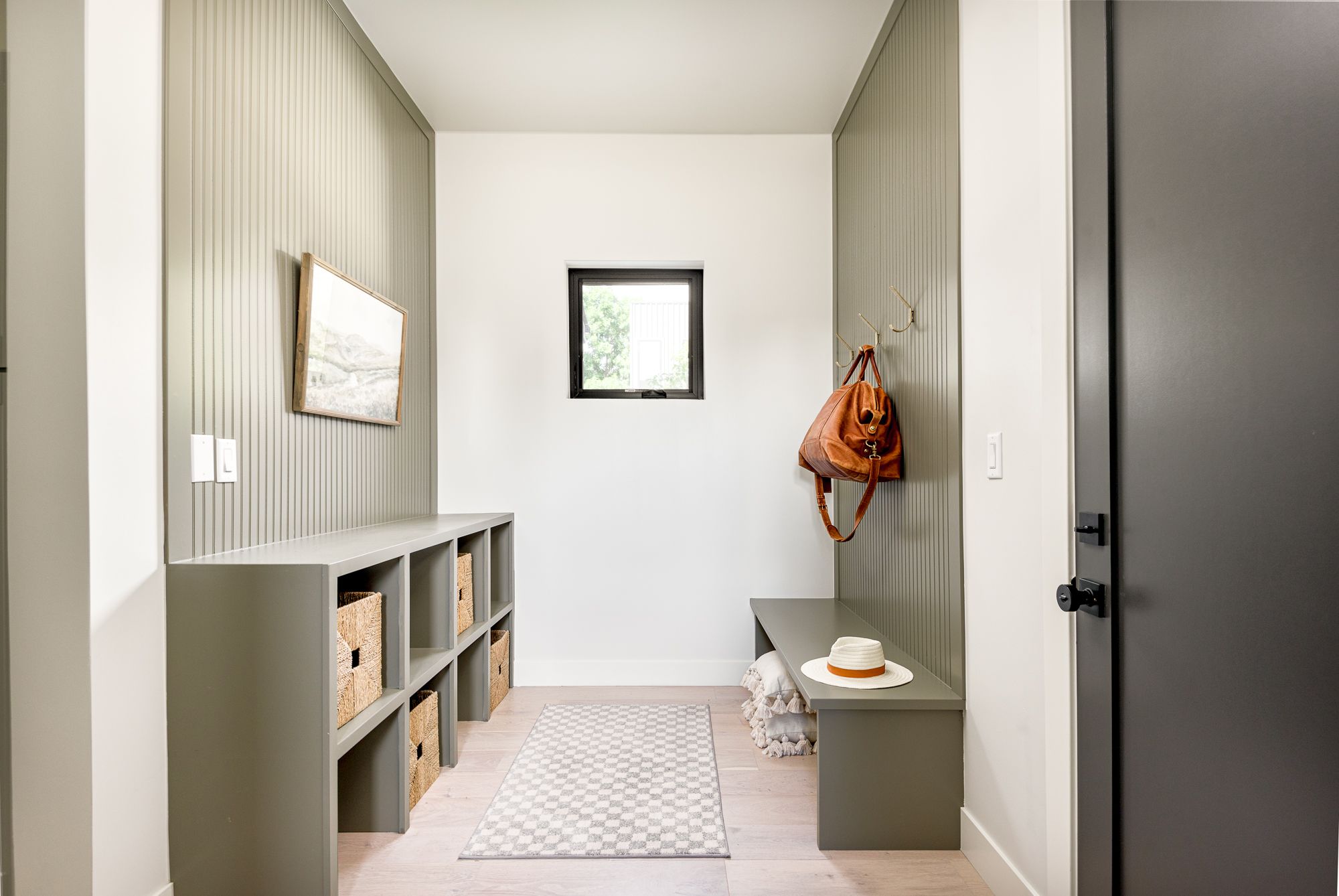 Mudroom bench with cubbies against a taupe slat wall