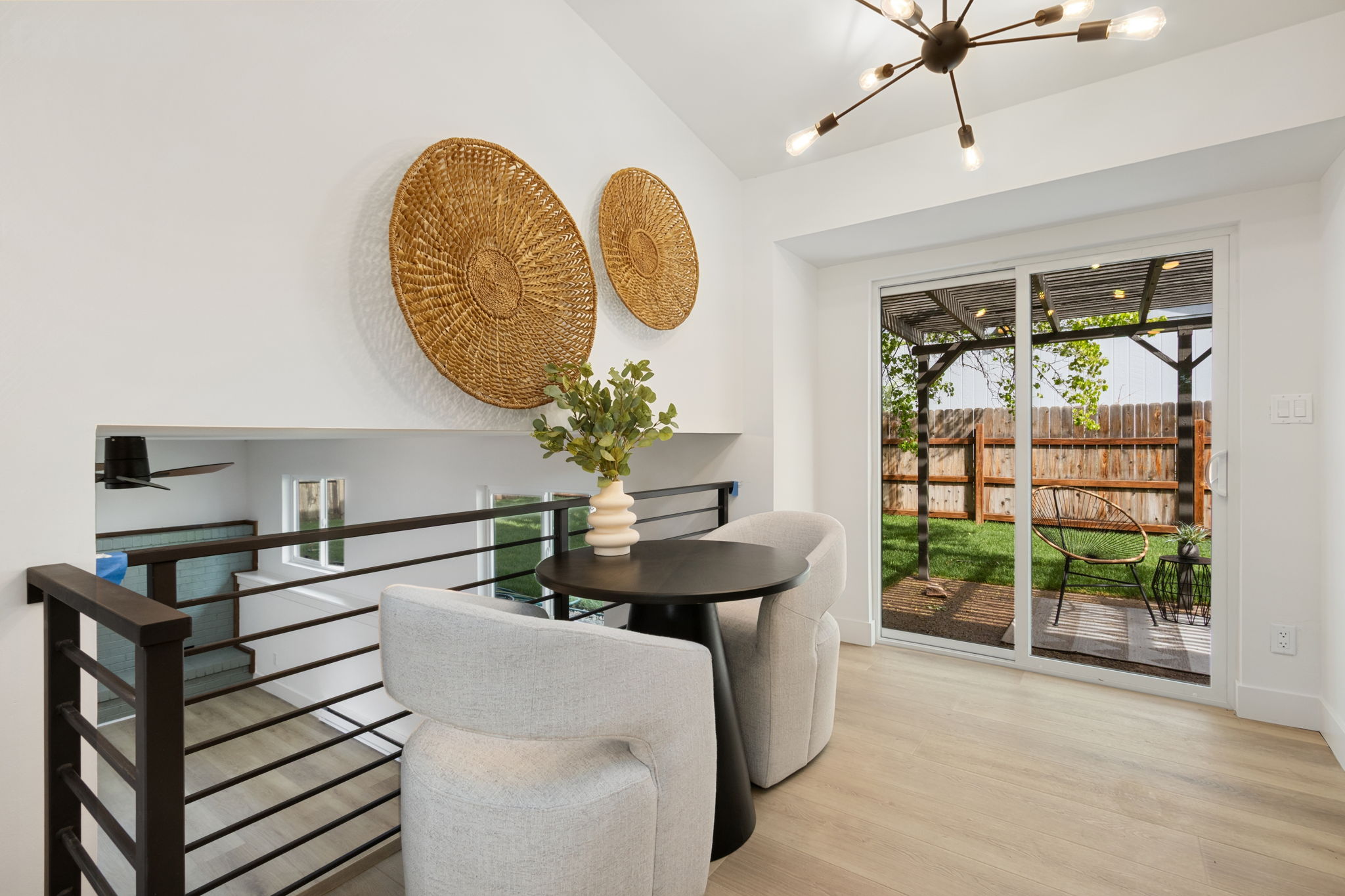 Dining nook with a sputnik-style light and a slider leading out to the pergola patio