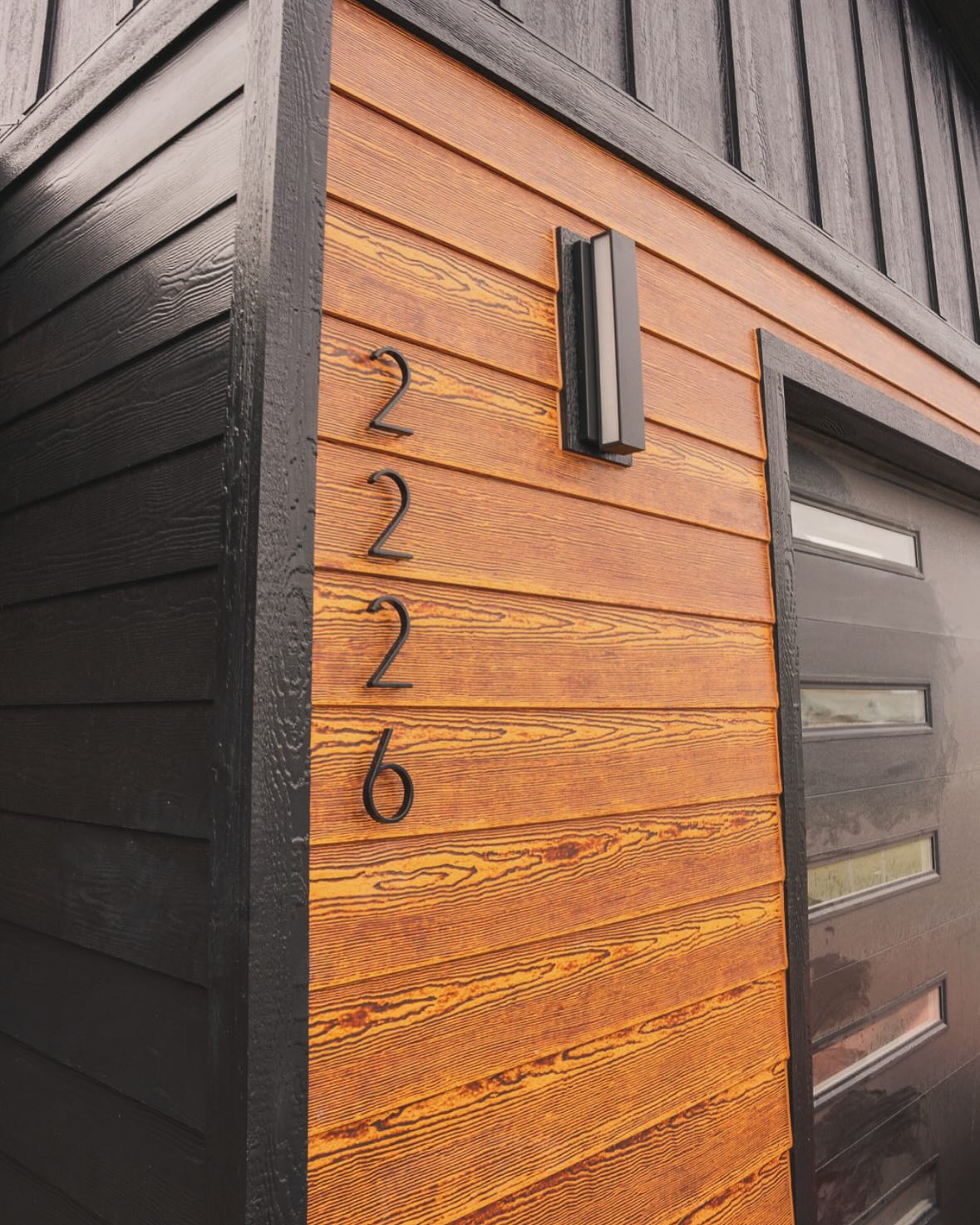 Cedar-look siding and black trim on a new home built by Double Diamond Construction