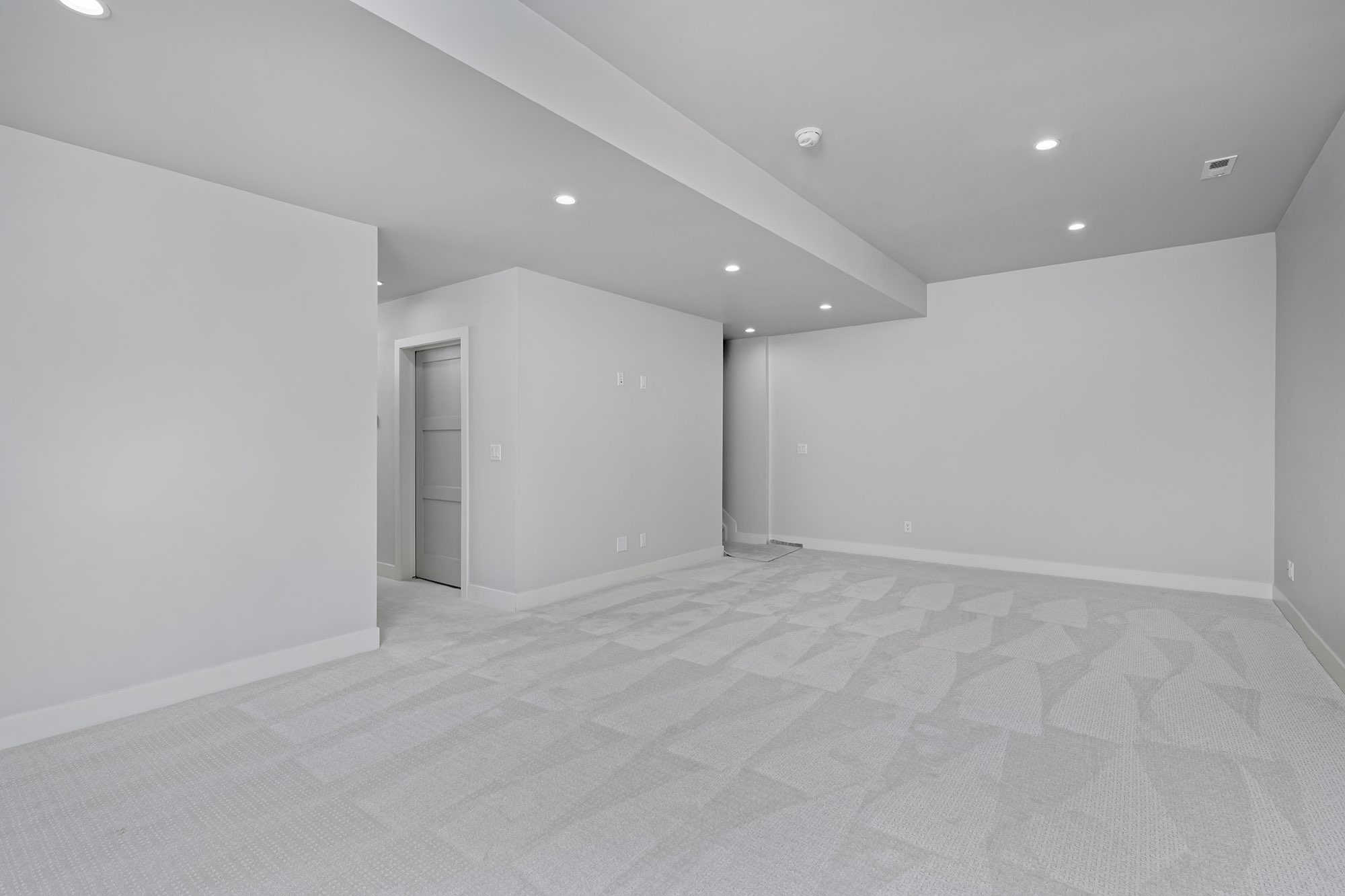 Lower level room with recessed lights, a soffit and light carpet