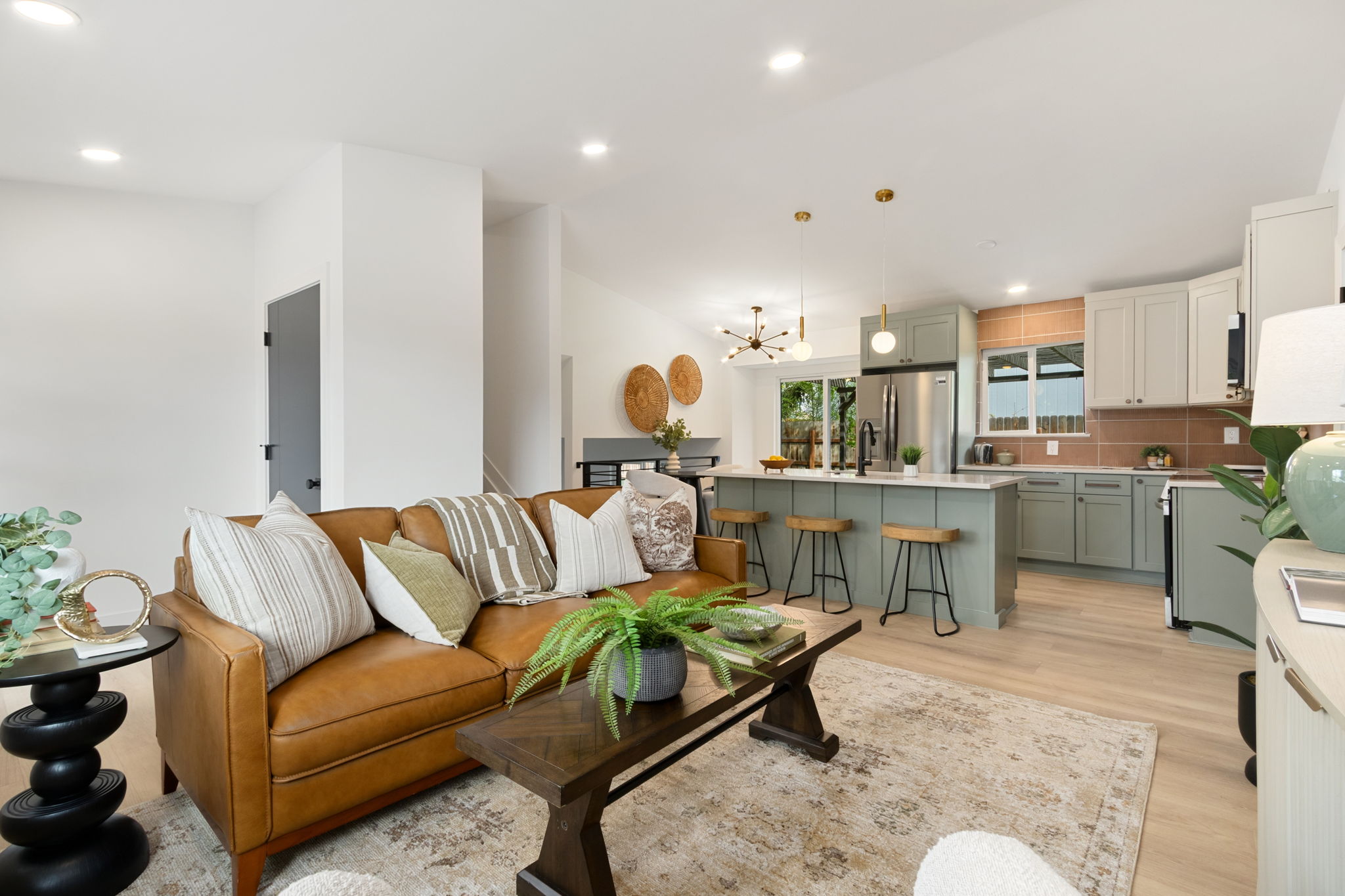 Wide view of the open main level with the living room, vaulted ceiling and kitchen together