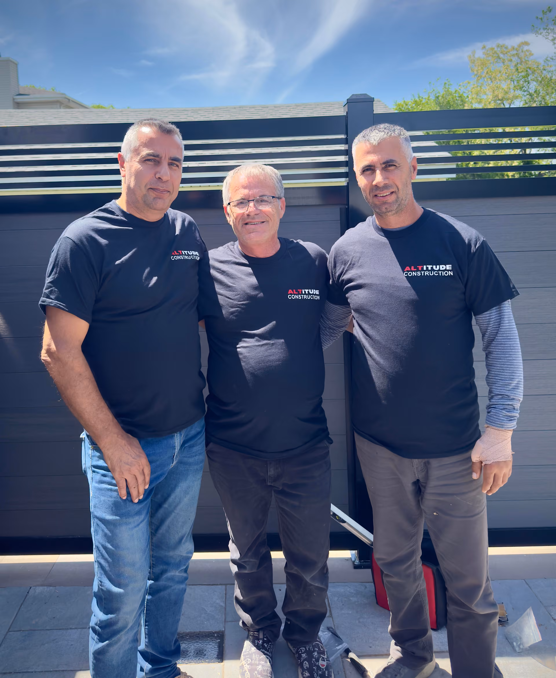 The Altitude Construction crew in front of a composite fence installation