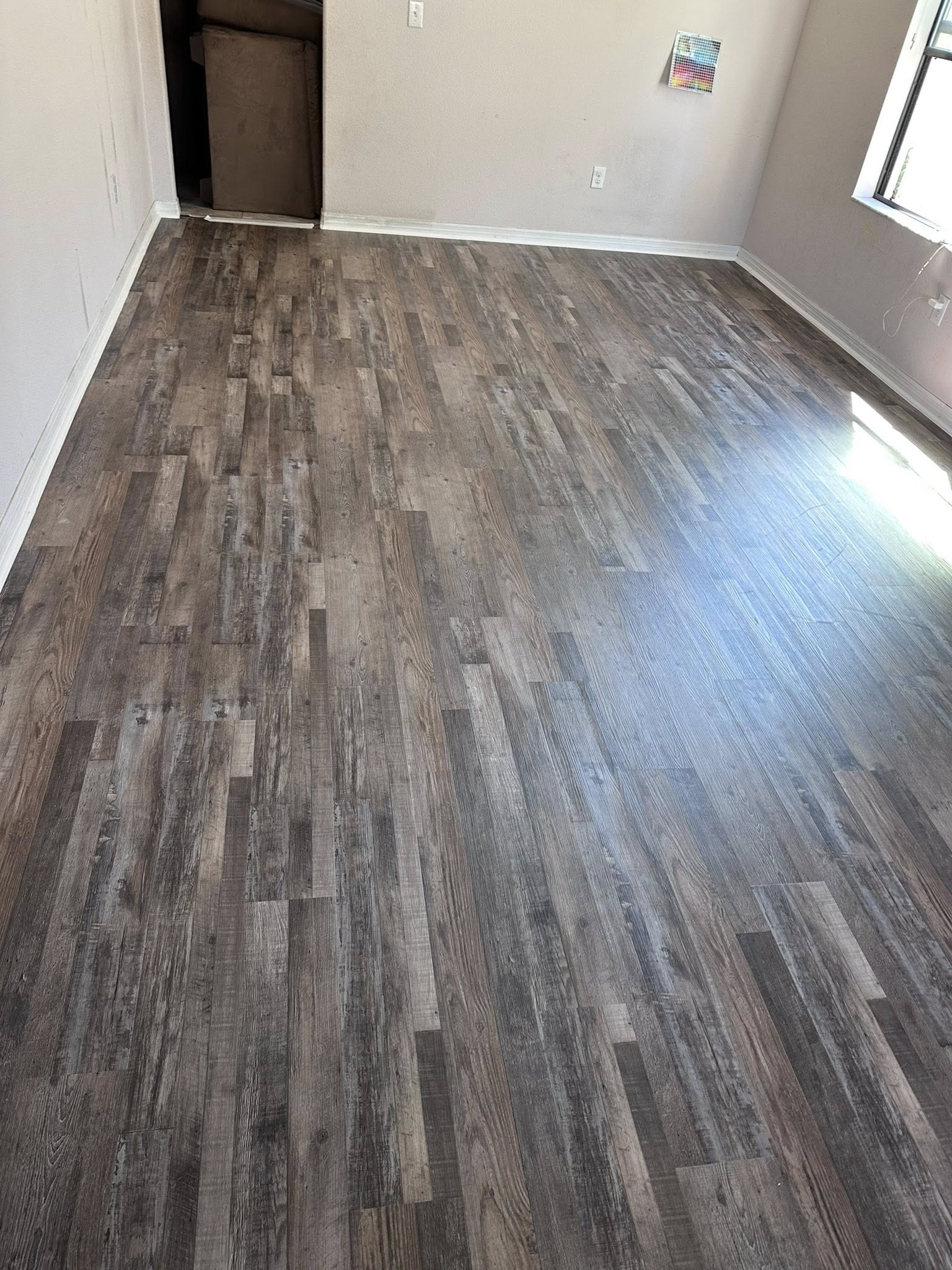 Empty Tampa, FL room with new grey plank flooring