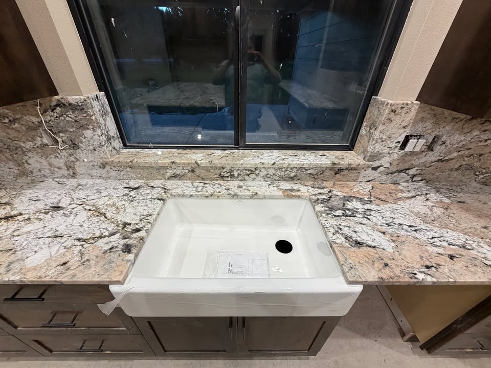 Veined granite countertop with farmhouse sink in a Roseburg kitchen — Luxury Granite Countertops