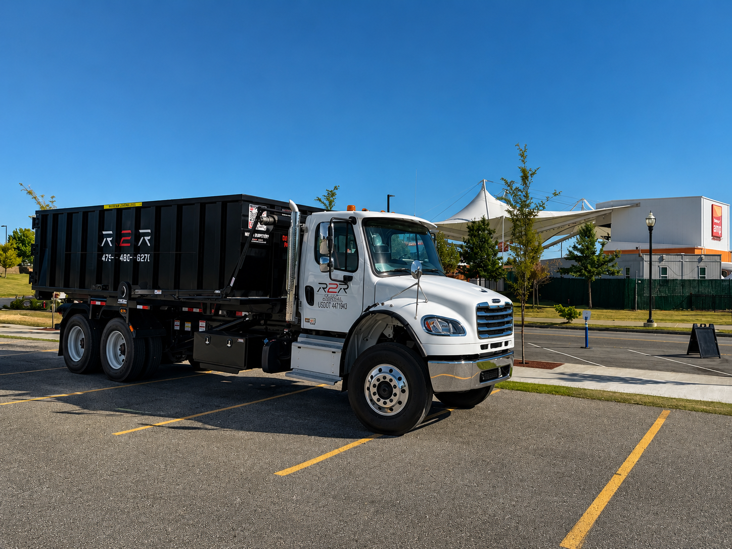 R2R Disposal roll-off truck with a loaded branded dumpster in Rogers, Arkansas