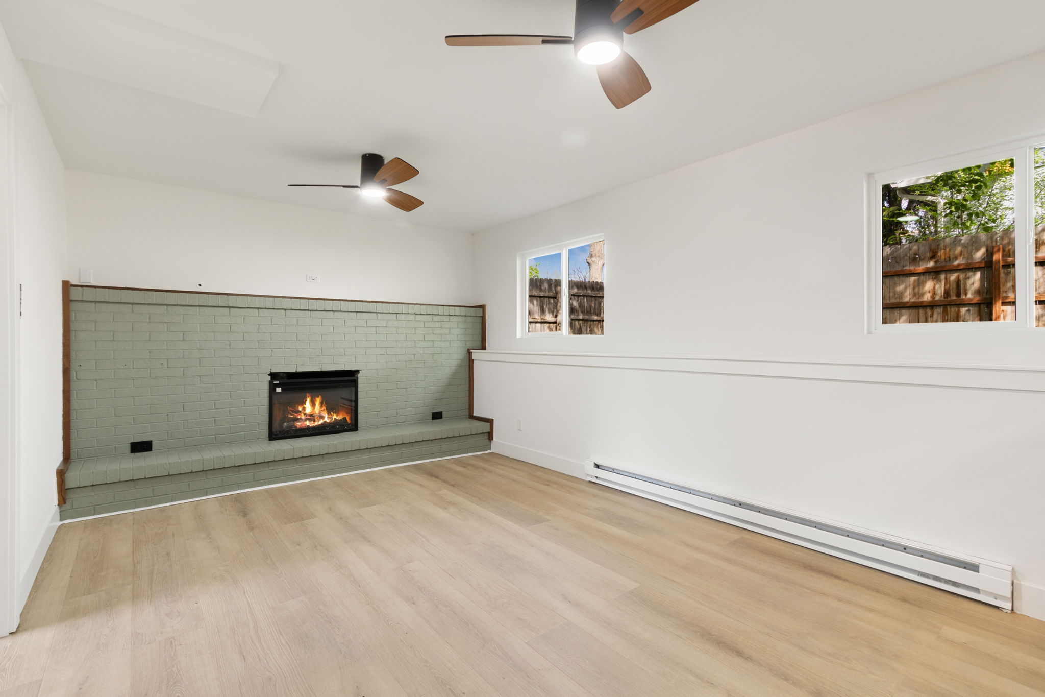The sage-painted brick fireplace seen from a different angle in the family room
