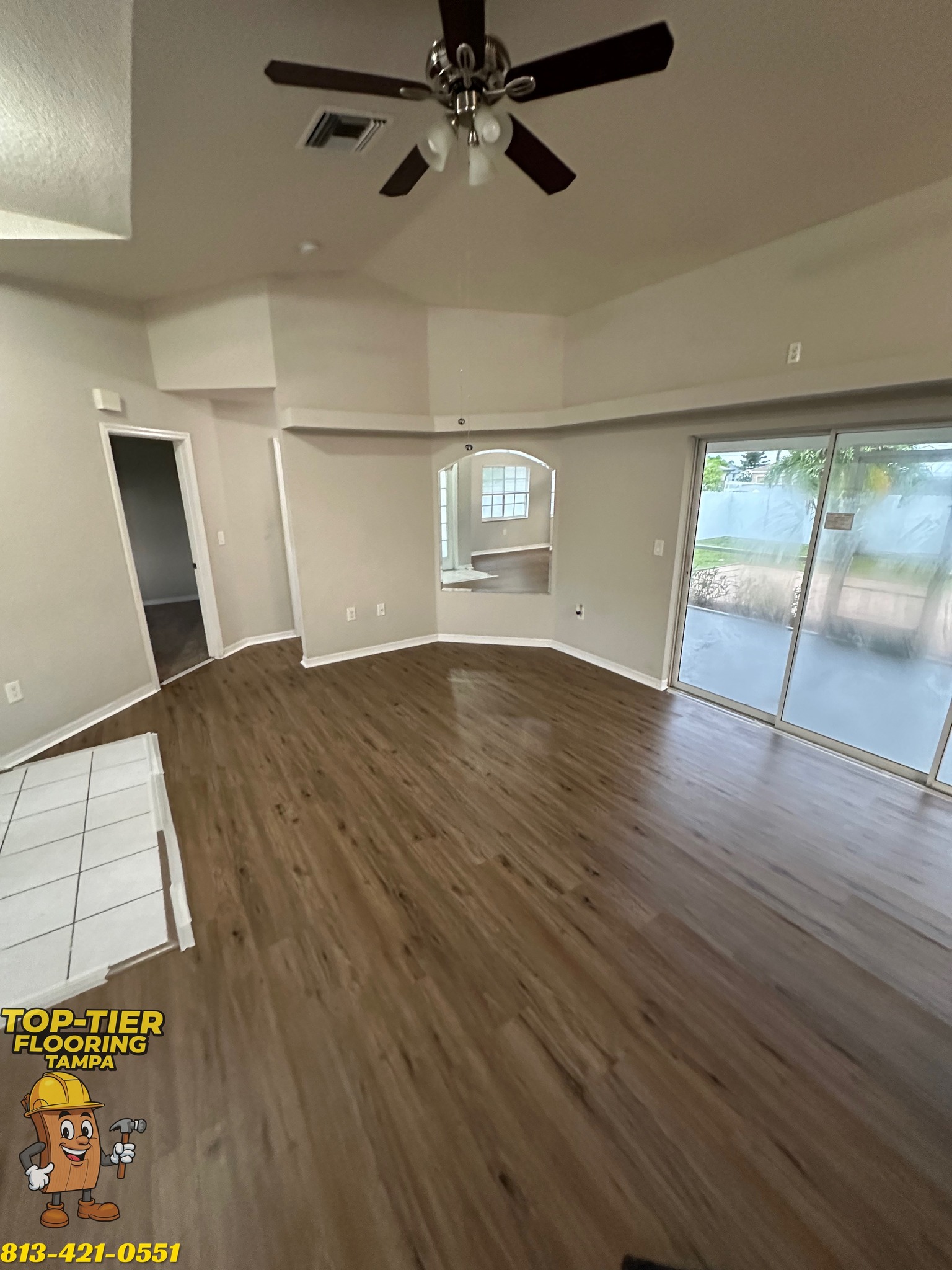 Empty great room in Tampa, FL with new dark plank flooring