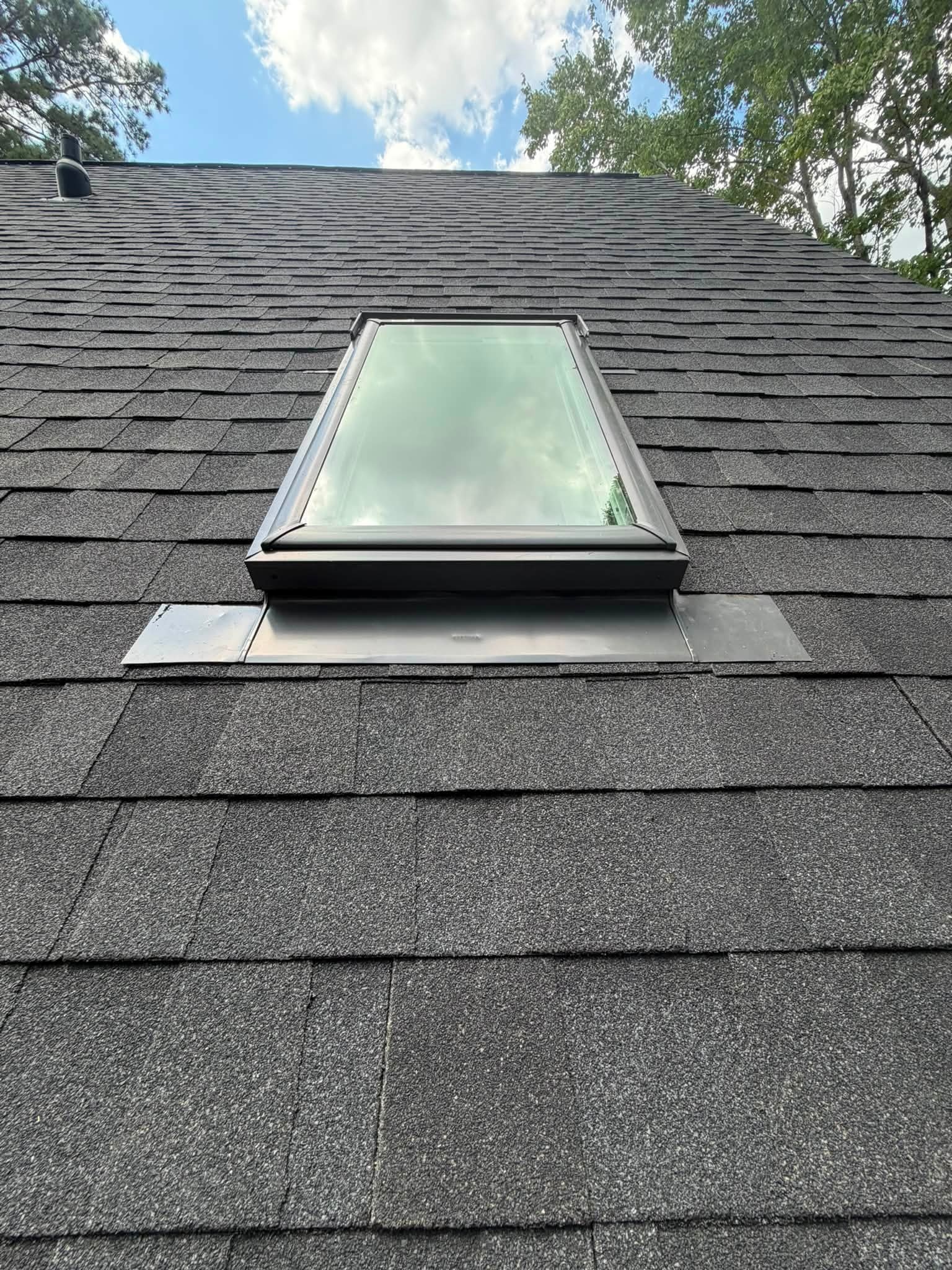 Installed skylight with new step flashing on a shingle roof