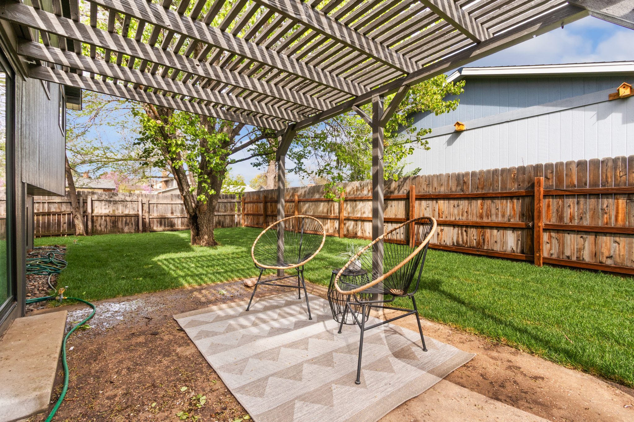 Pergola-covered patio off the back slider of the split-level