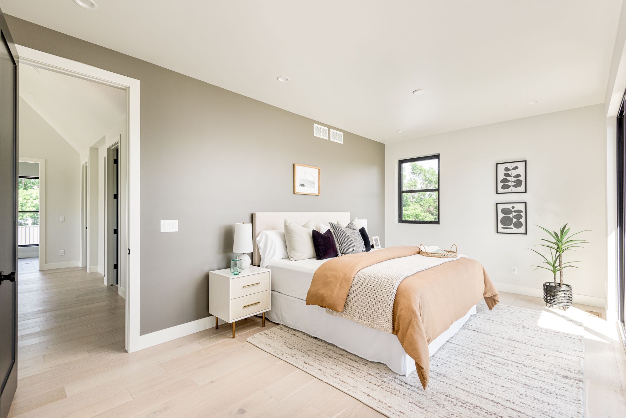 Primary bedroom with a warm taupe accent wall