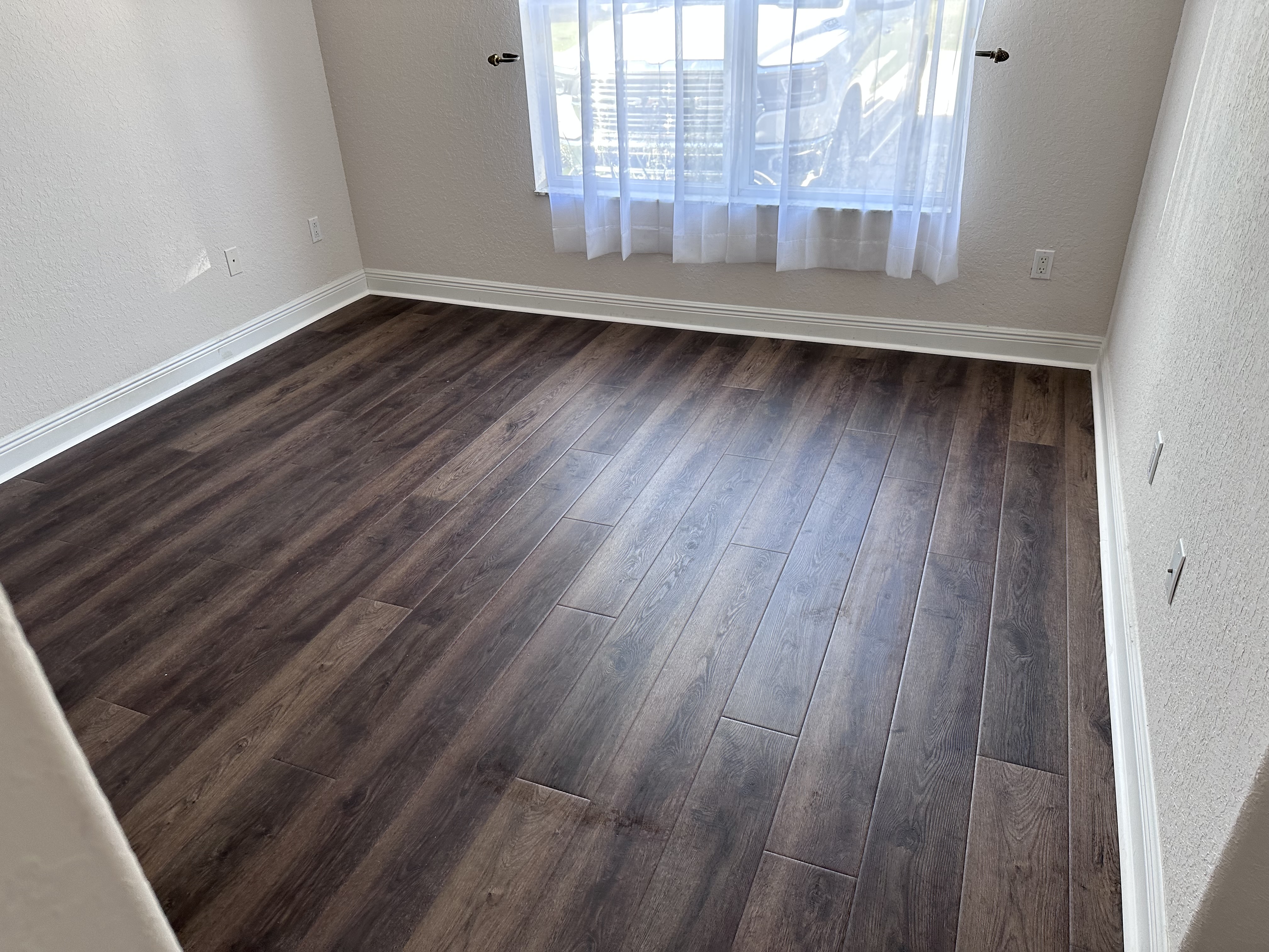 Empty Tampa, FL bedroom with new dark plank flooring