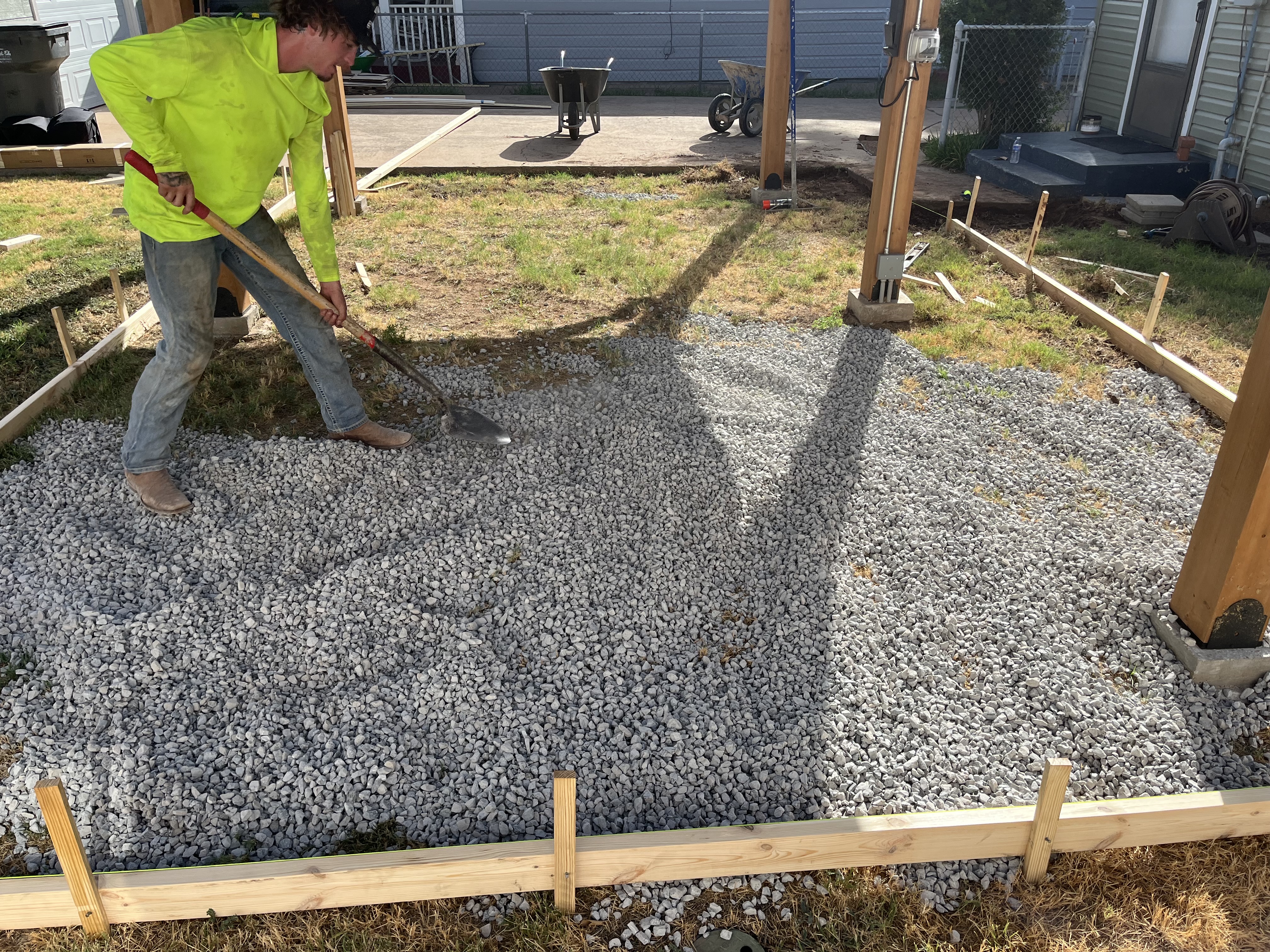 Gravel base leveled inside wood forms for a patio by Rock of Ages Concrete LLC