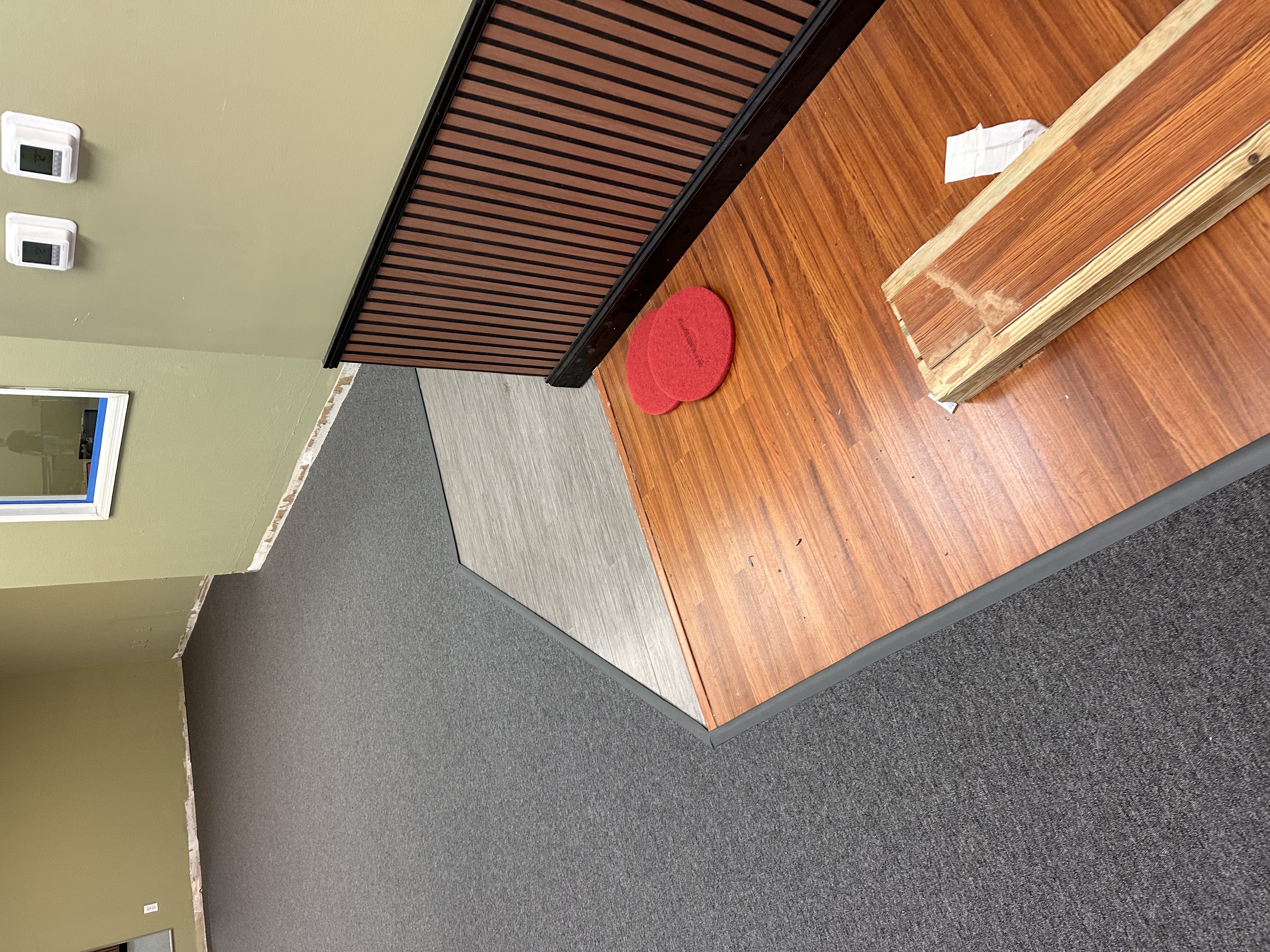 Commercial space in Tampa, FL with new grey carpet transitioning to plank flooring