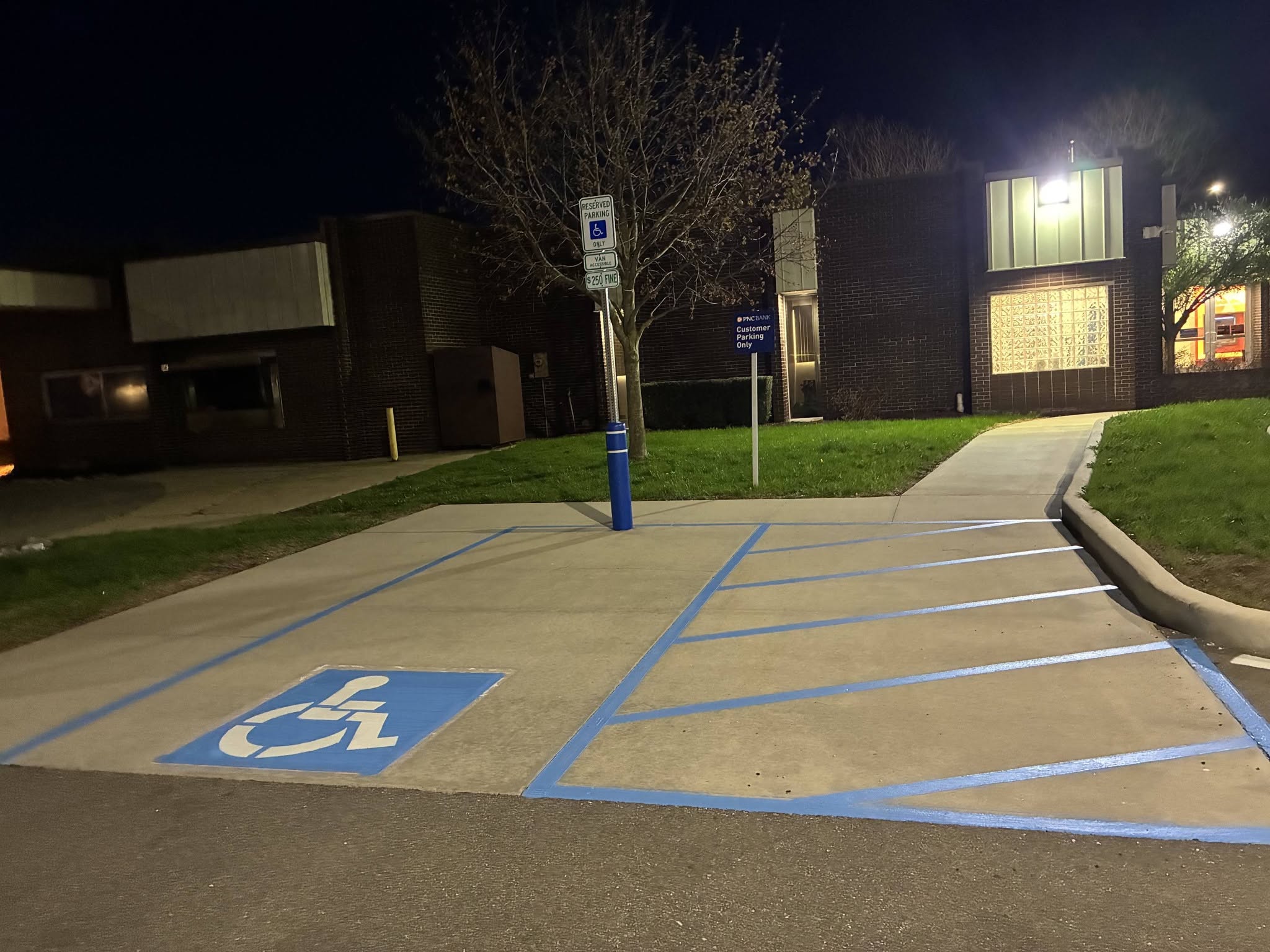 Accessible stall and hatched access aisle finished under the lot lights