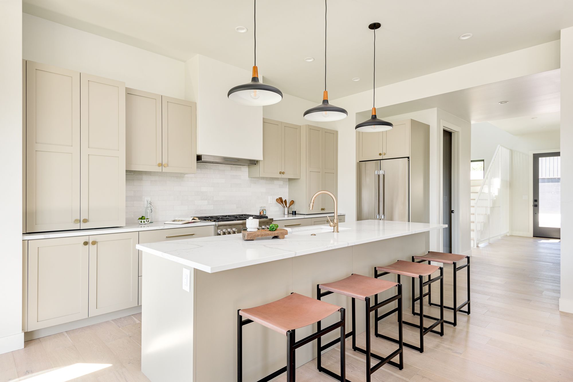 View down the kitchen island from the living room toward the pro-style range