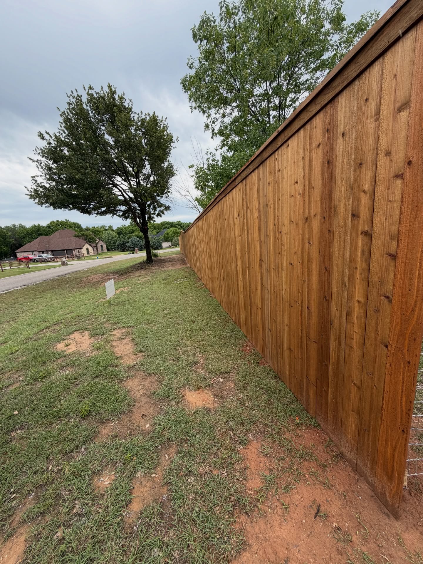 Cedar privacy fence with a finished top rail, built by Bighorn Bros Construction near Granbury, Texas