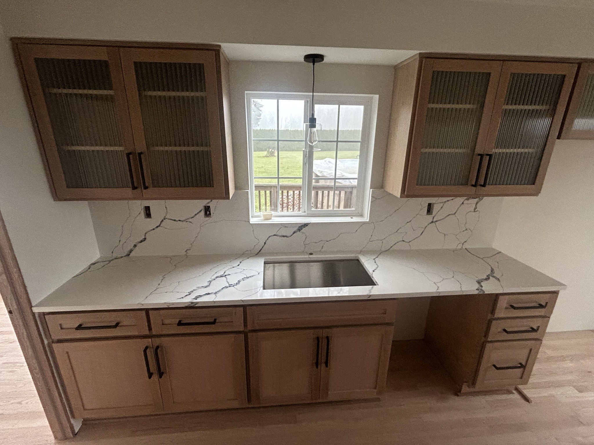 Full-height marble slab backsplash behind kitchen range