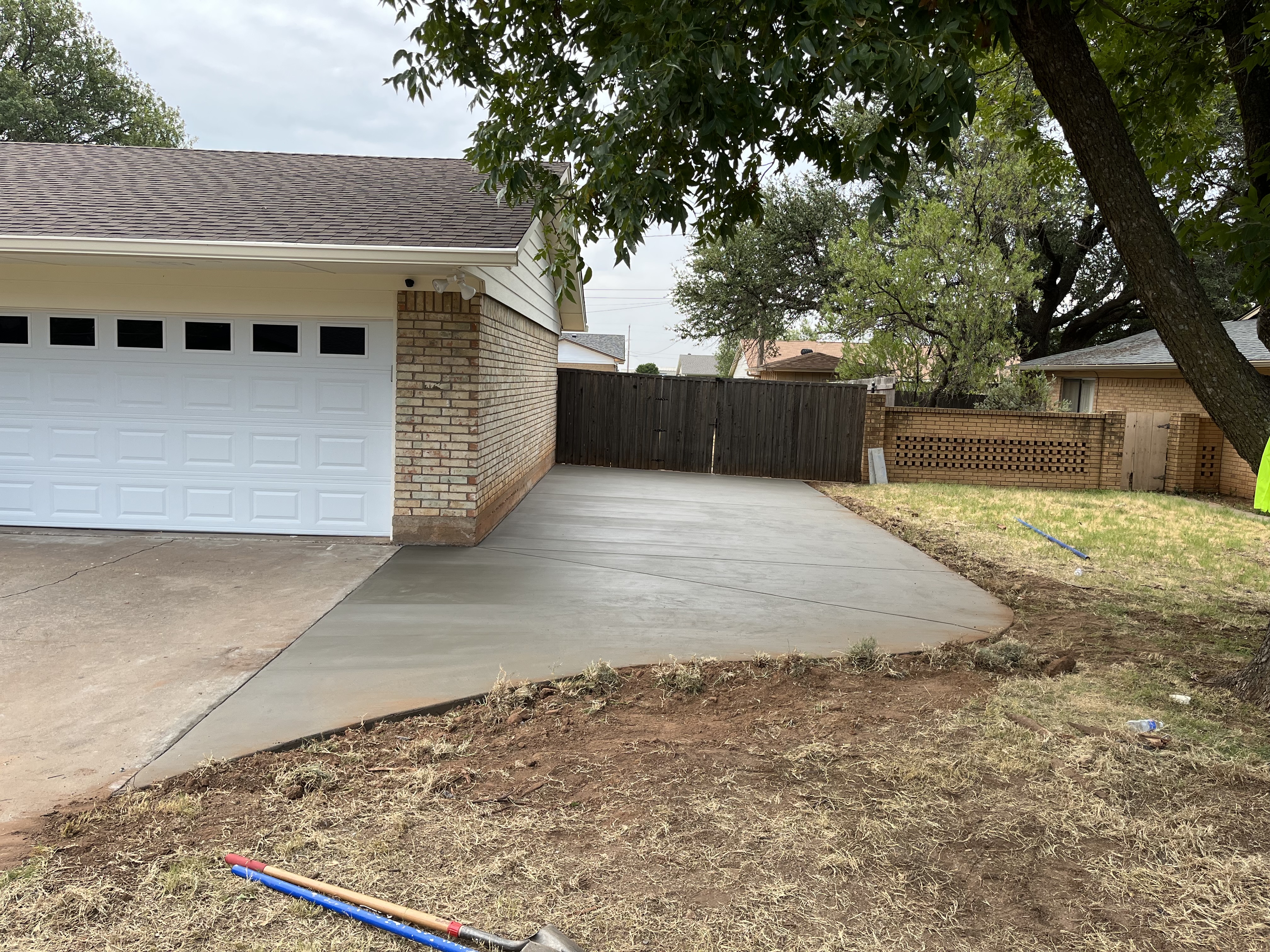 Residential concrete driveway replacement poured in front of garage by Rock of Ages Concrete LLC