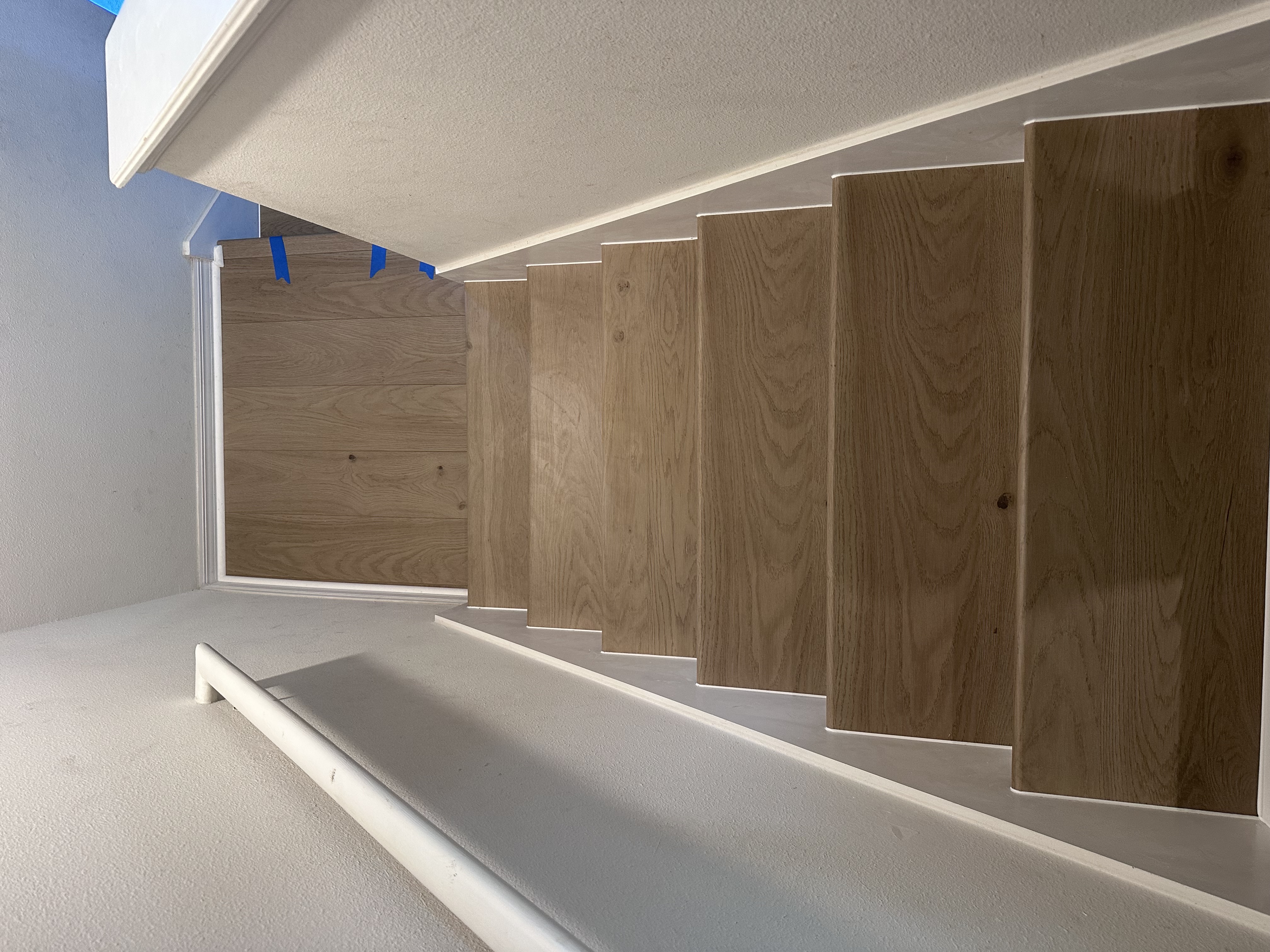 Staircase in a Tampa, FL home mid-install with new light oak plank treads