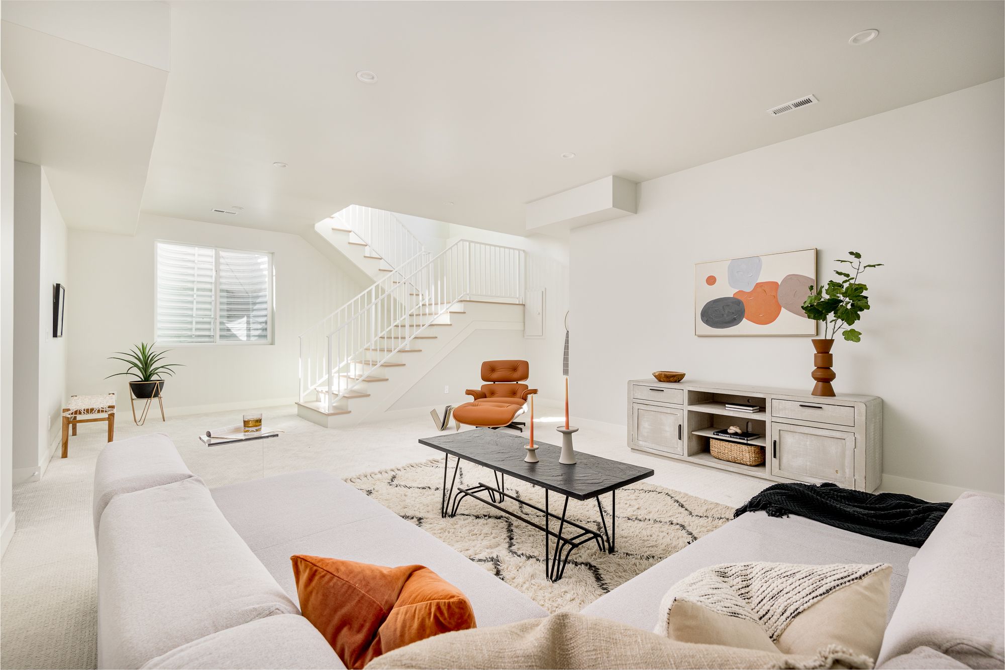 Finished lower-level family room with plush carpet and a sectional