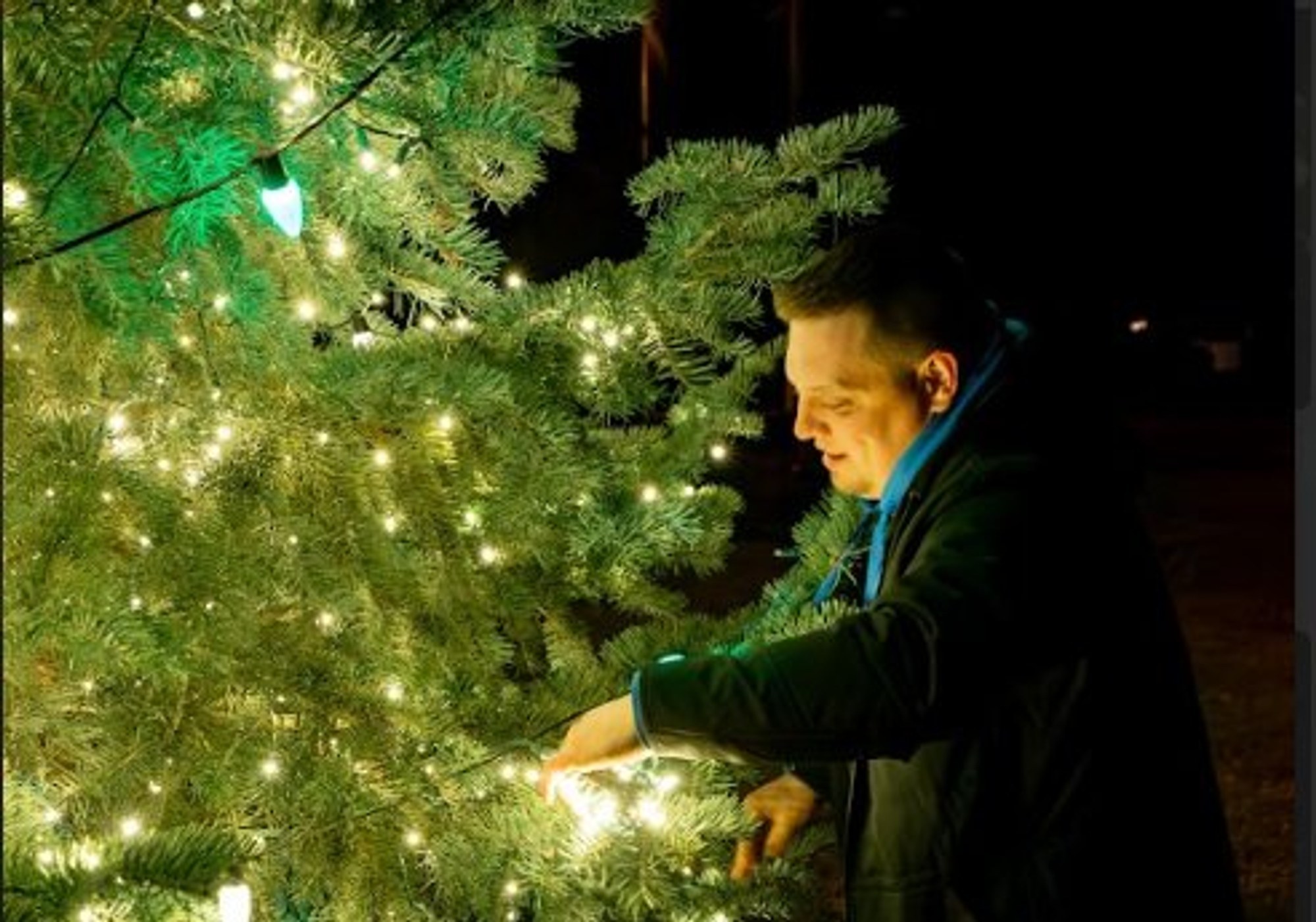 Technician servicing a lit tree during the season