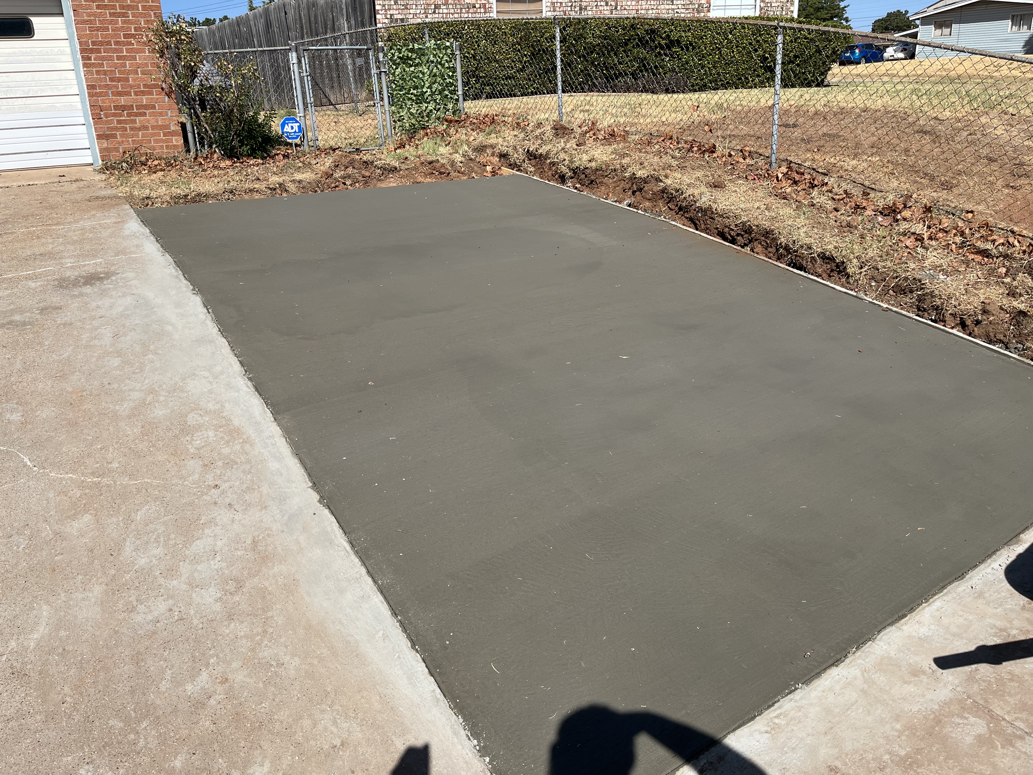 New concrete driveway section poured in a yard by Rock of Ages Concrete LLC