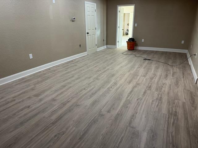 Light grey luxury vinyl plank flooring finished through a mobile home hallway and doorway
