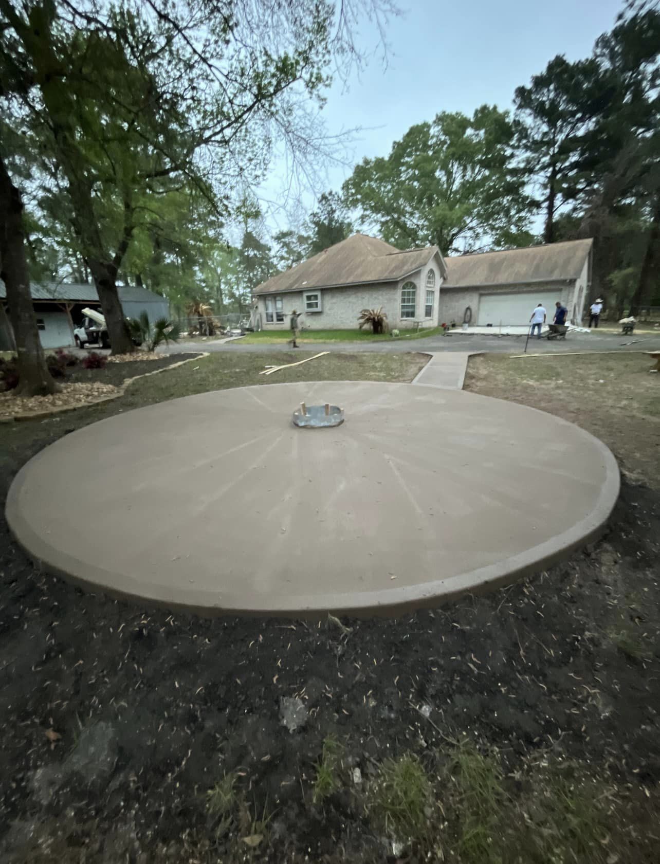 Finished circular concrete patio pad in a Greater Houston backyard