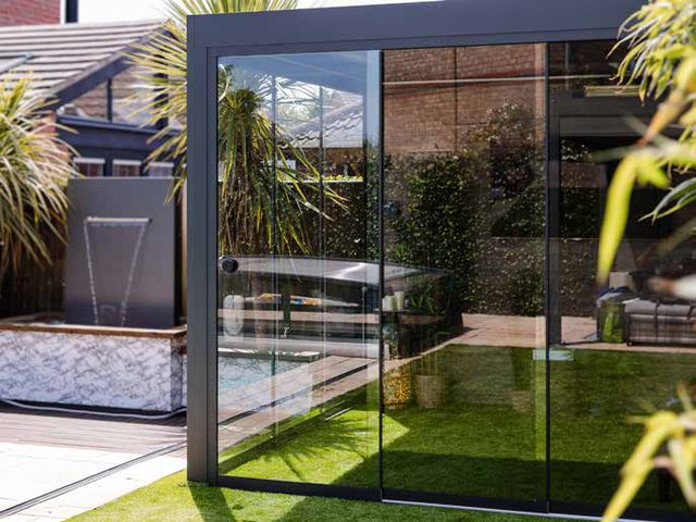 Series 3 PERGOLUX pergola over an outdoor kitchen on a paver patio