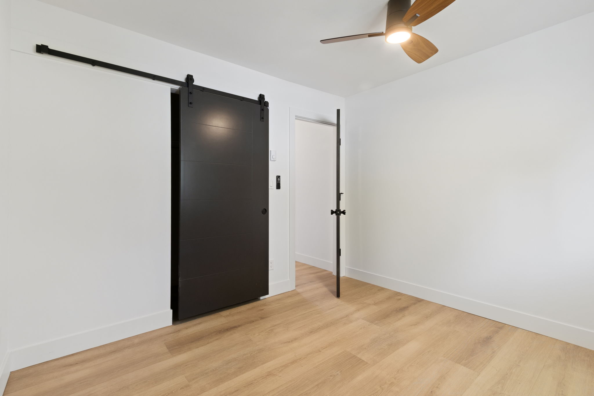 Black sliding barn door on its track
