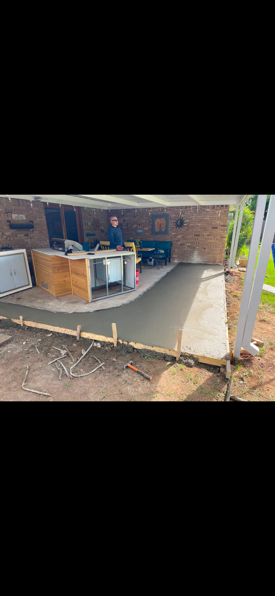 Narrow backyard concrete patio slab poured behind a house by Rock of Ages Concrete LLC