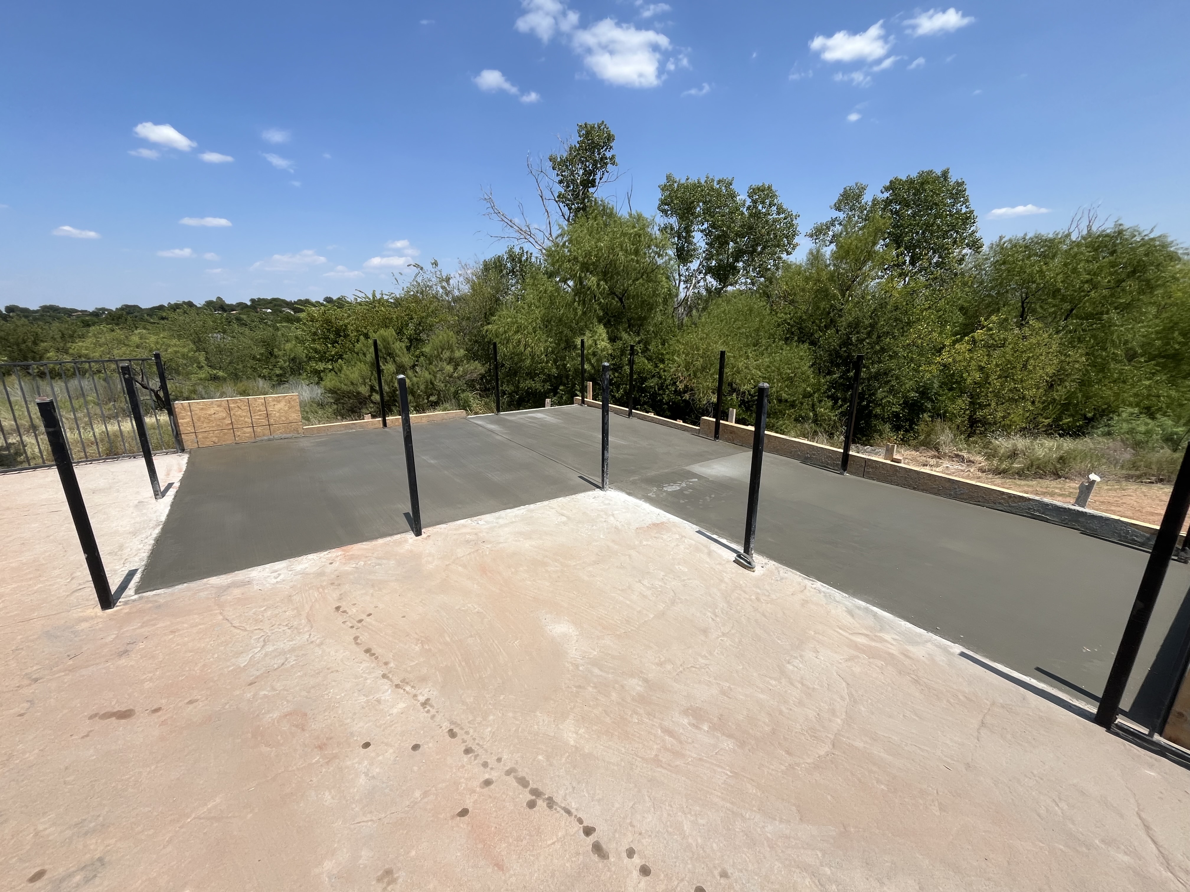 Concrete slab pad poured in a backyard lawn area by Rock of Ages Concrete LLC