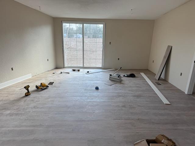 Luxury vinyl plank installation reaching a sliding glass door in a mobile home living room