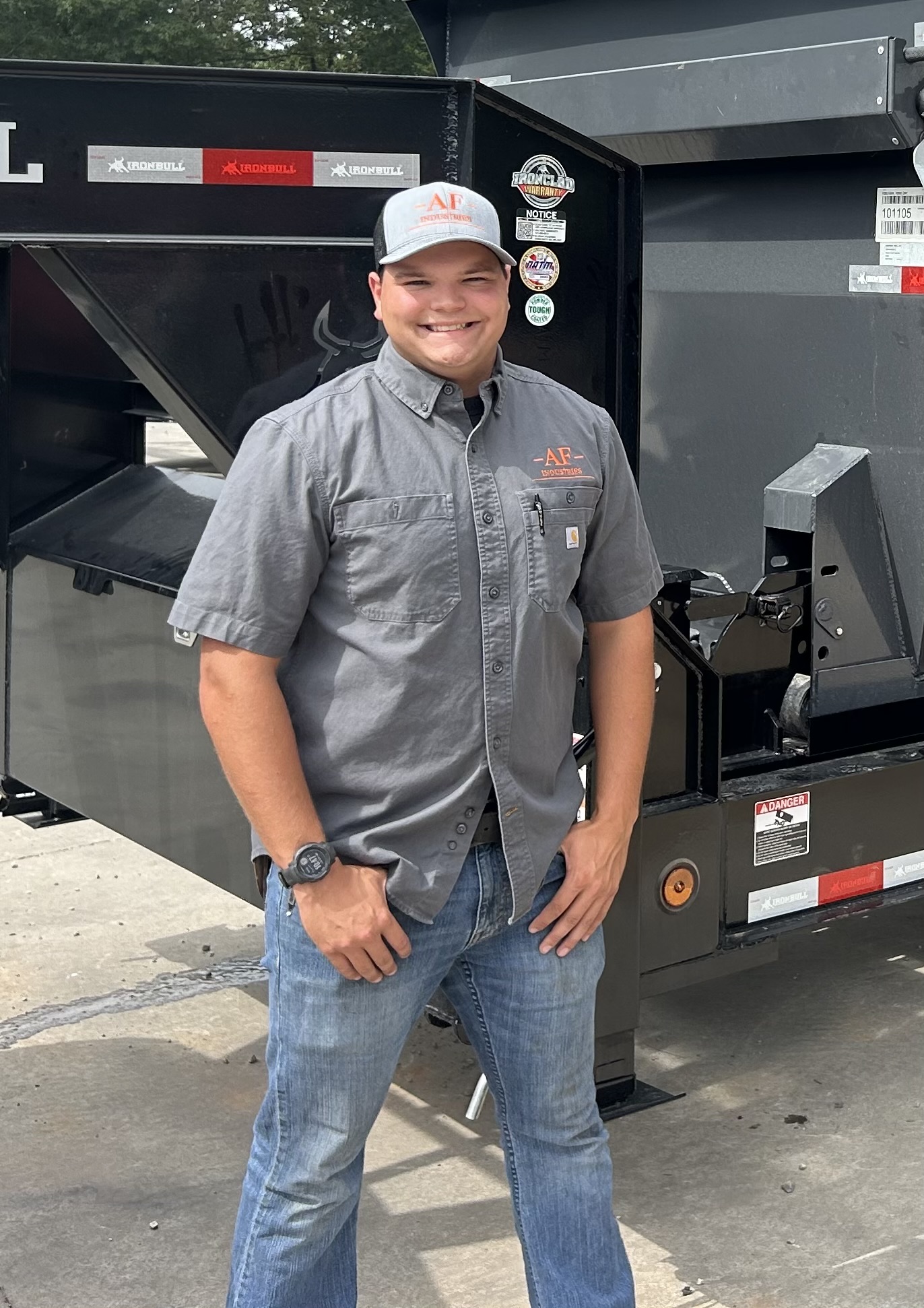 Aiden Fisher, owner of AFIndustries, standing beside a dumpster trailer in Jefferson County, WV