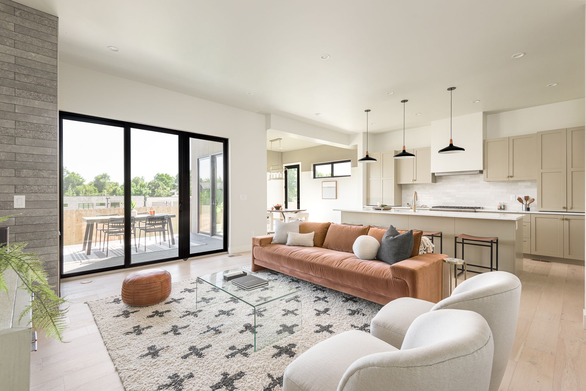 Living room looking toward the kitchen, with white oak floors and a wall of black sliding doors