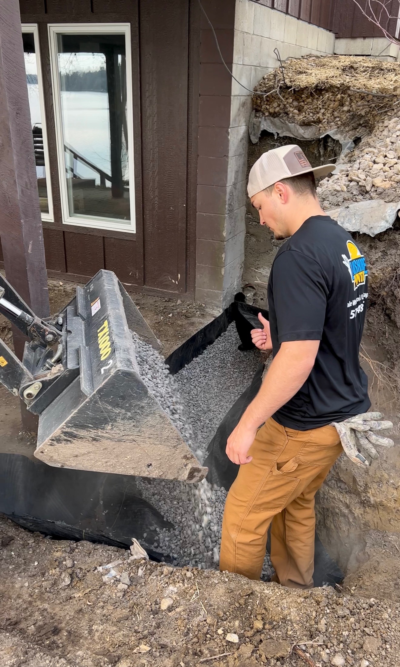 Logan running a skid steer on a landscaping job