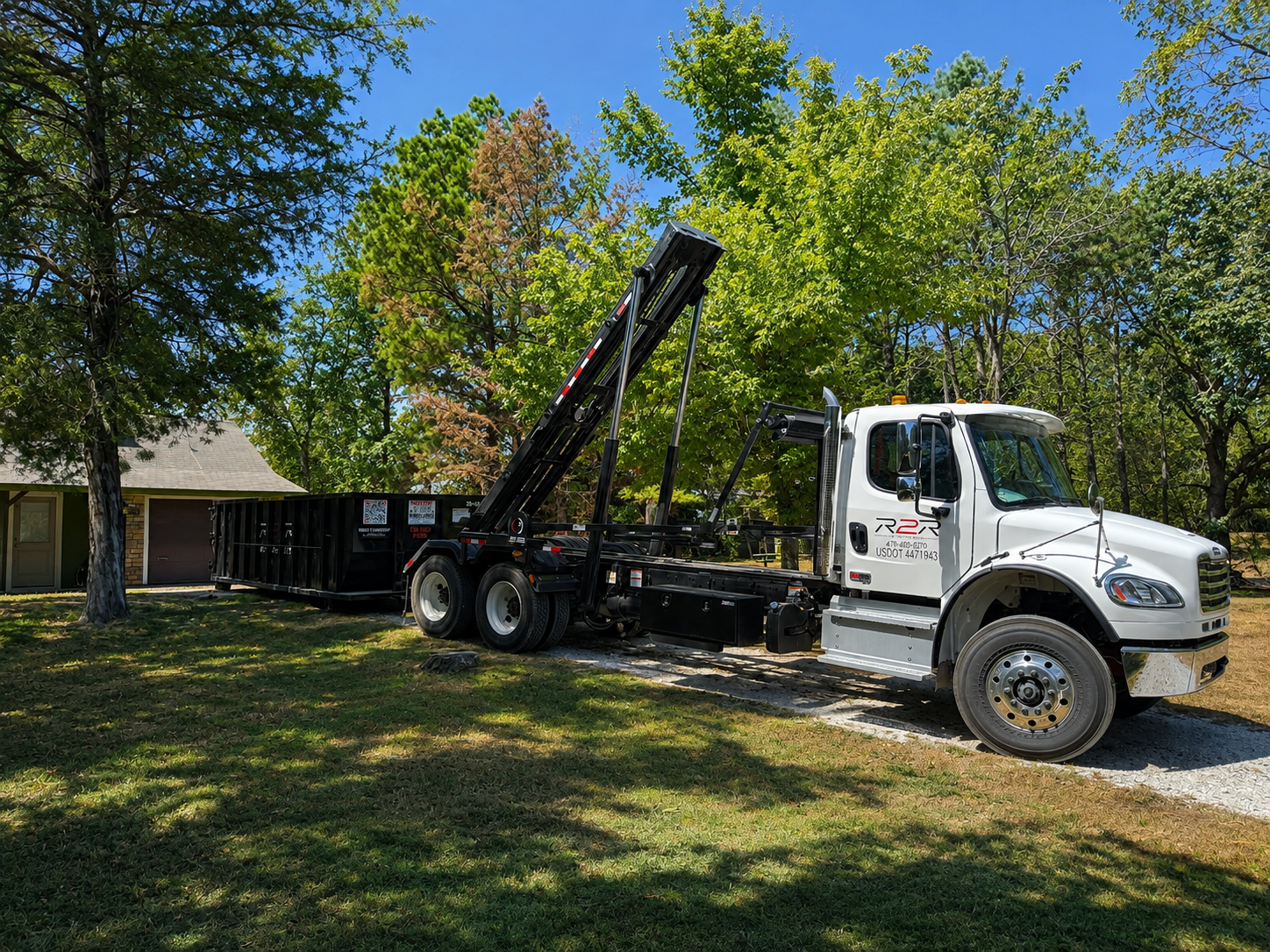 R2R truck setting a roll-off dumpster at a residential property in Northwest Arkansas