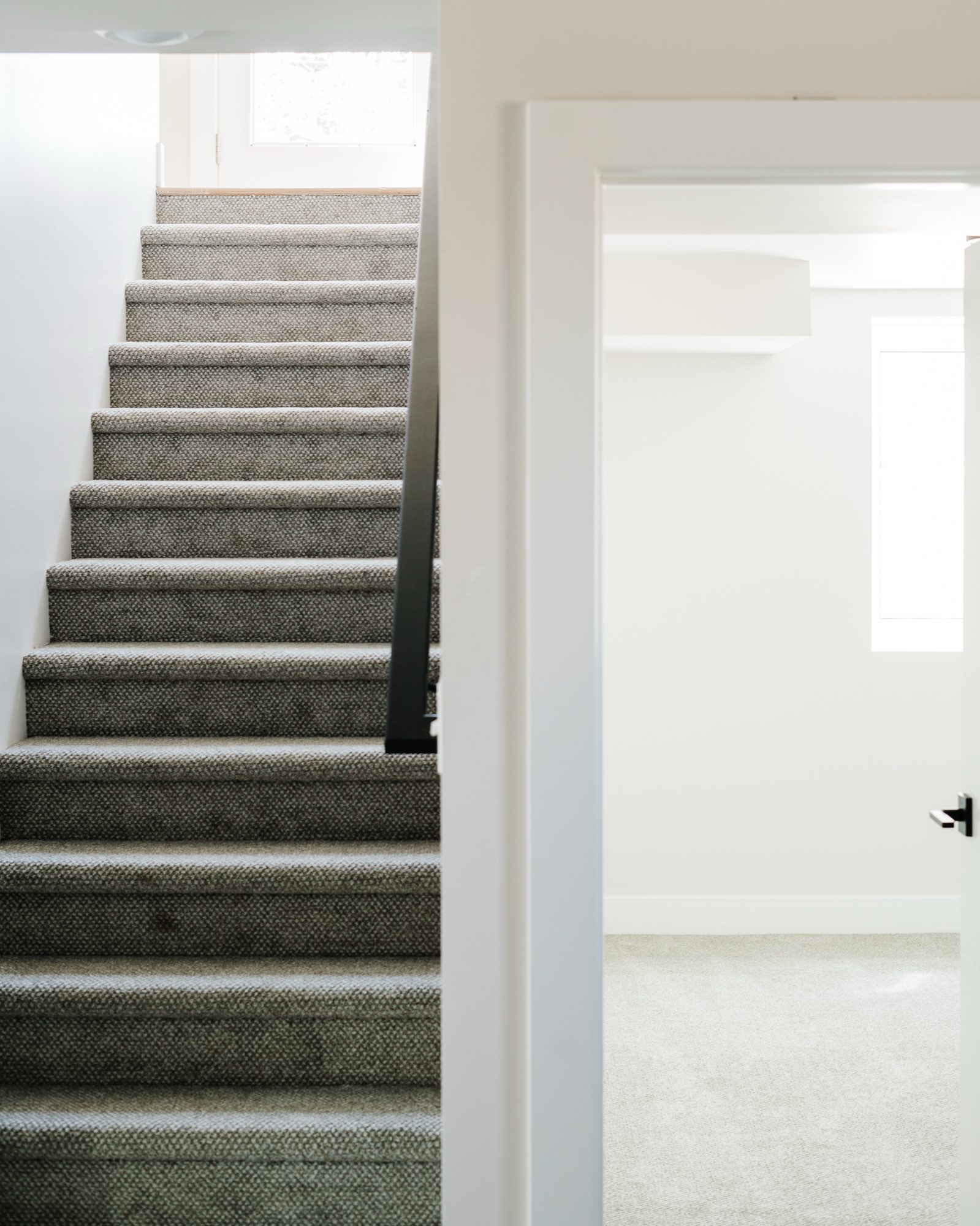 Close view of the carpeted stair and an open white door