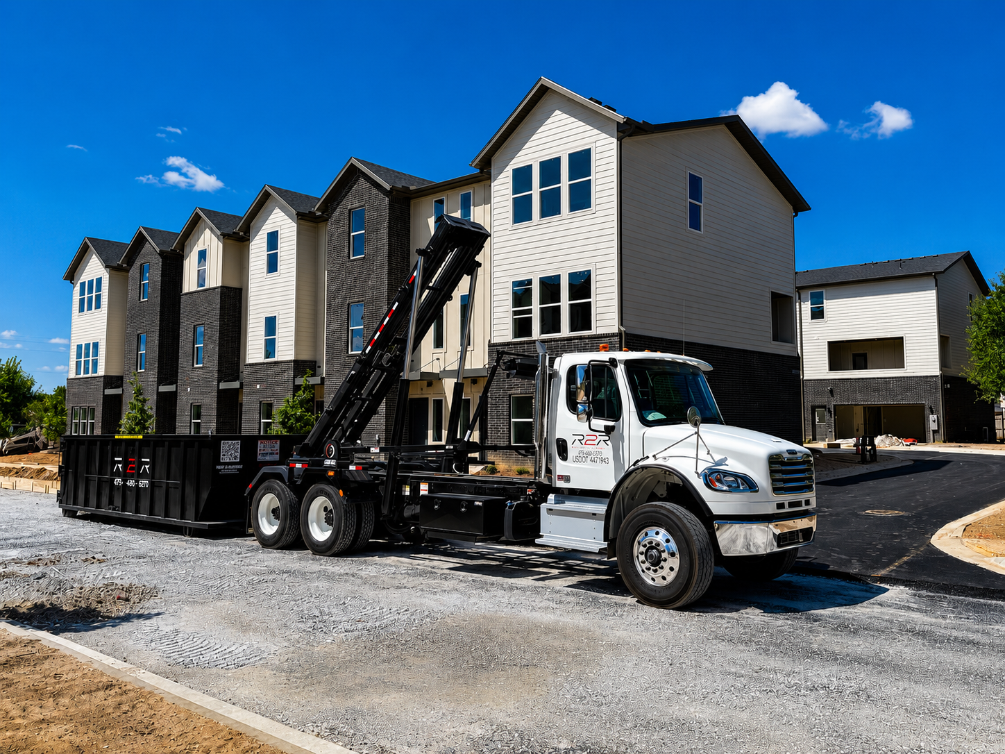 R2R truck setting a roll-off dumpster at a multi-family construction site in Northwest Arkansas