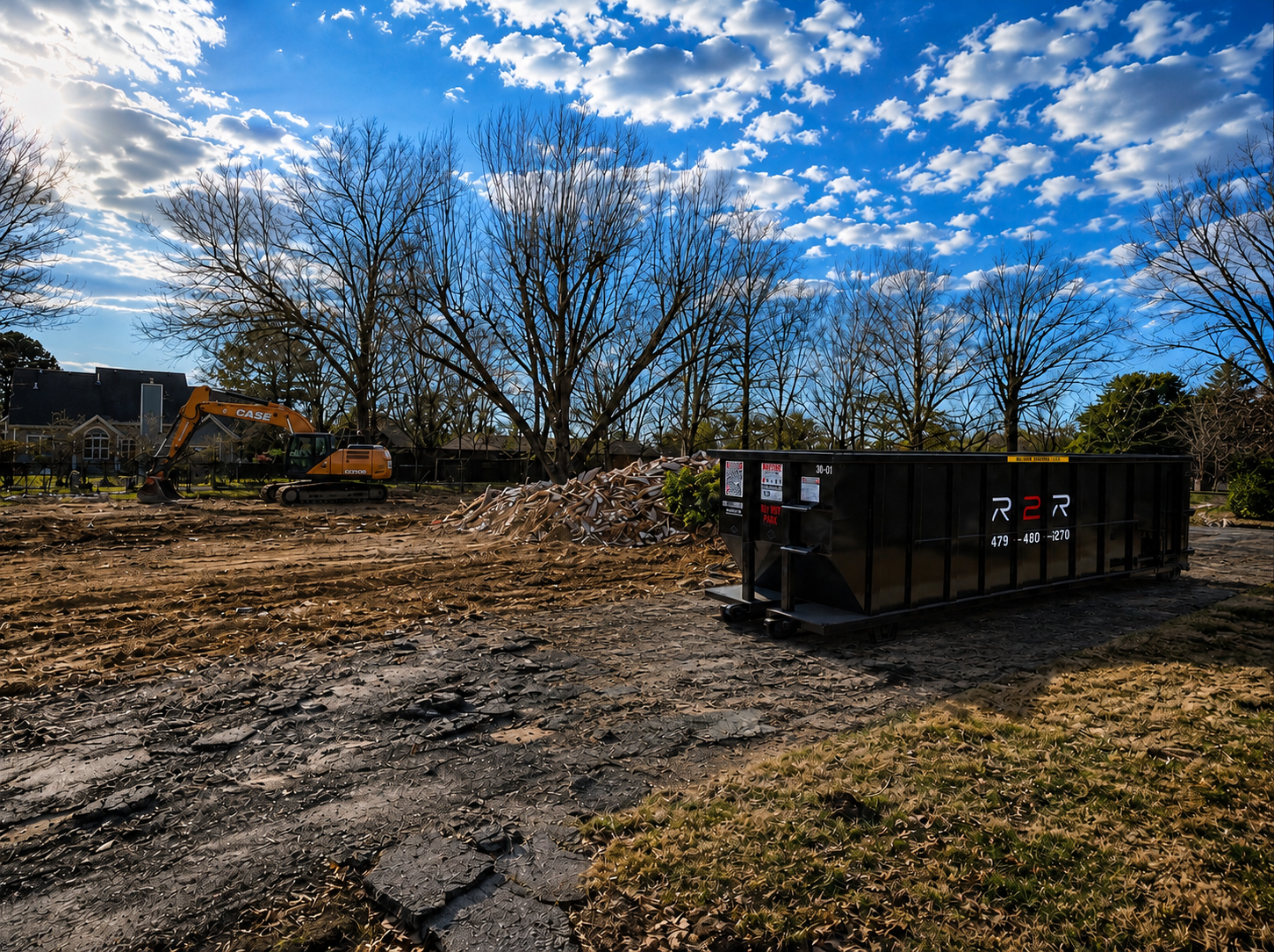 Cleared and graded lot after an R2R demolition, with the dumpster still on site