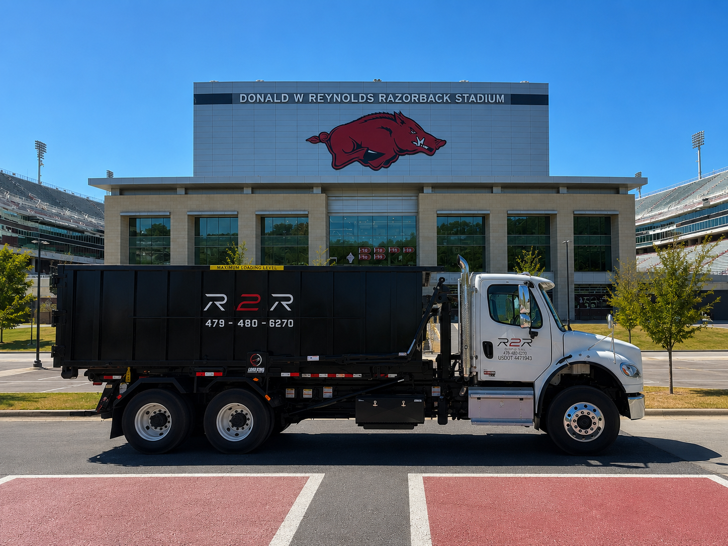R2R roll-off truck with a loaded branded dumpster in Fayetteville, Arkansas