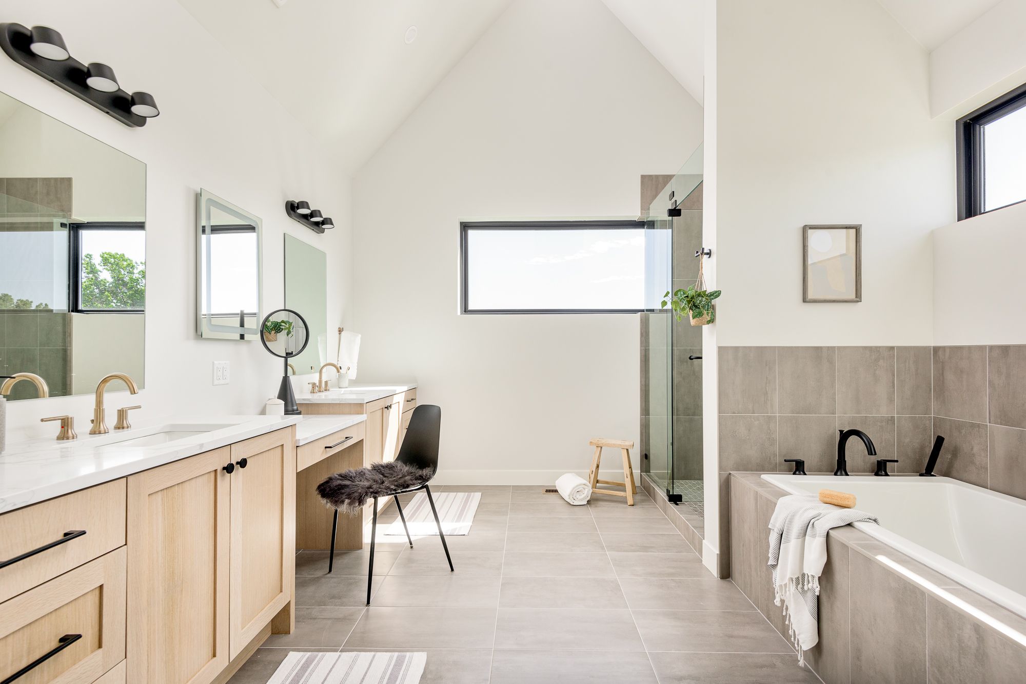 Wide view of the primary bathroom under a vaulted ceiling